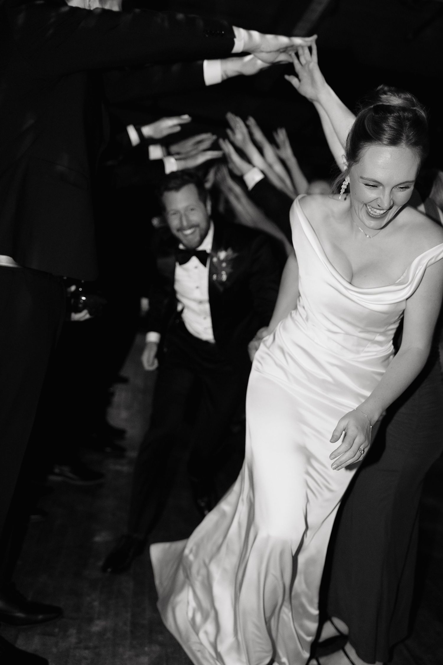 A sequence of black and white photos showing a bride in a white dress dancing and twirling at a wedding reception.