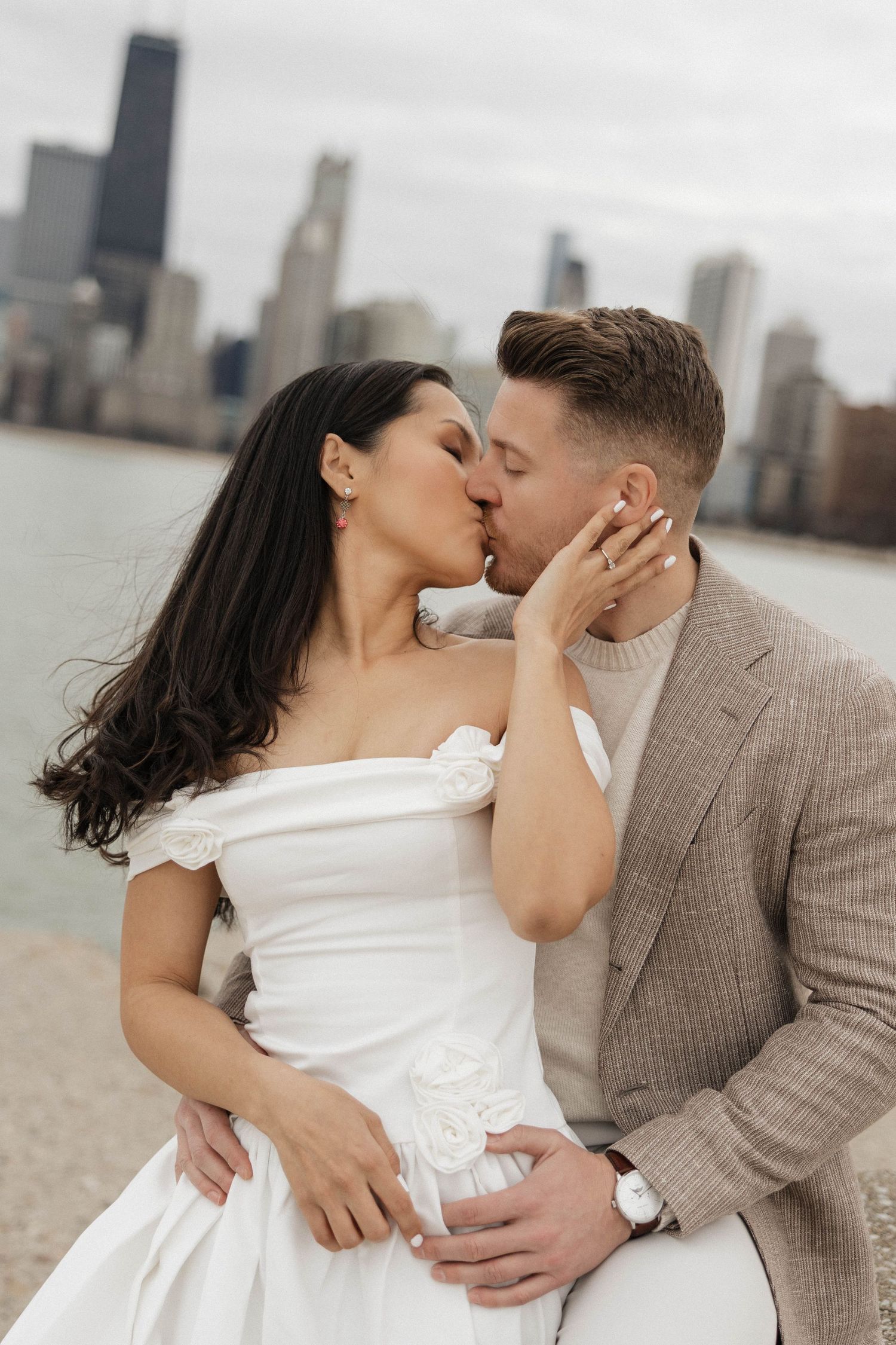 Bride and groom sharing a romantic kiss by Chicago lakefront with skyline.