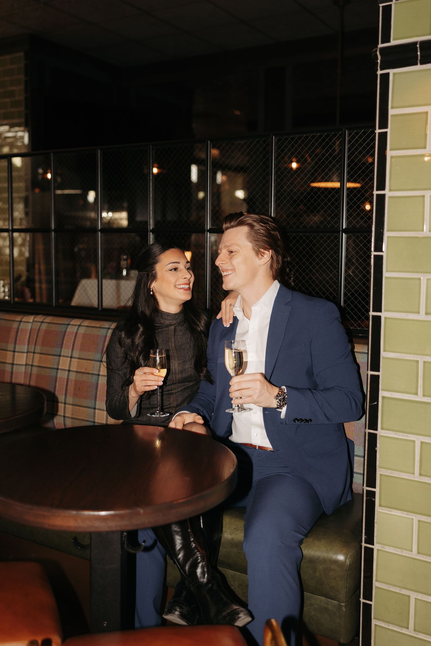 A couple enjoying conversation and laughter at a cozy restaurant table.