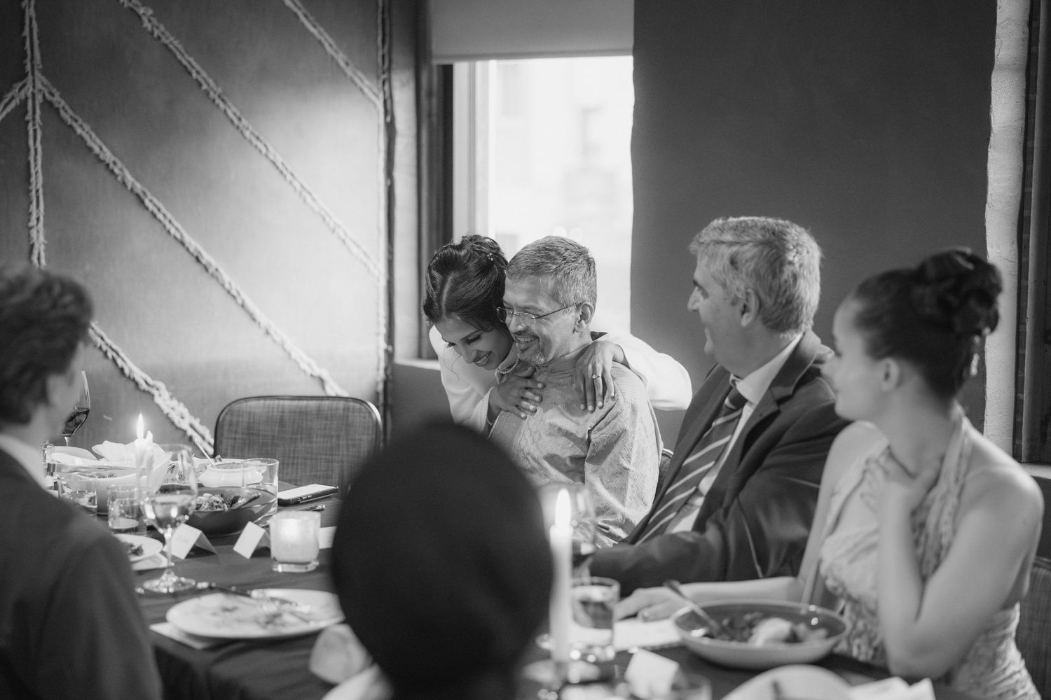 A black and white photo series shows people dining together at a table in what appears to be a home setting.