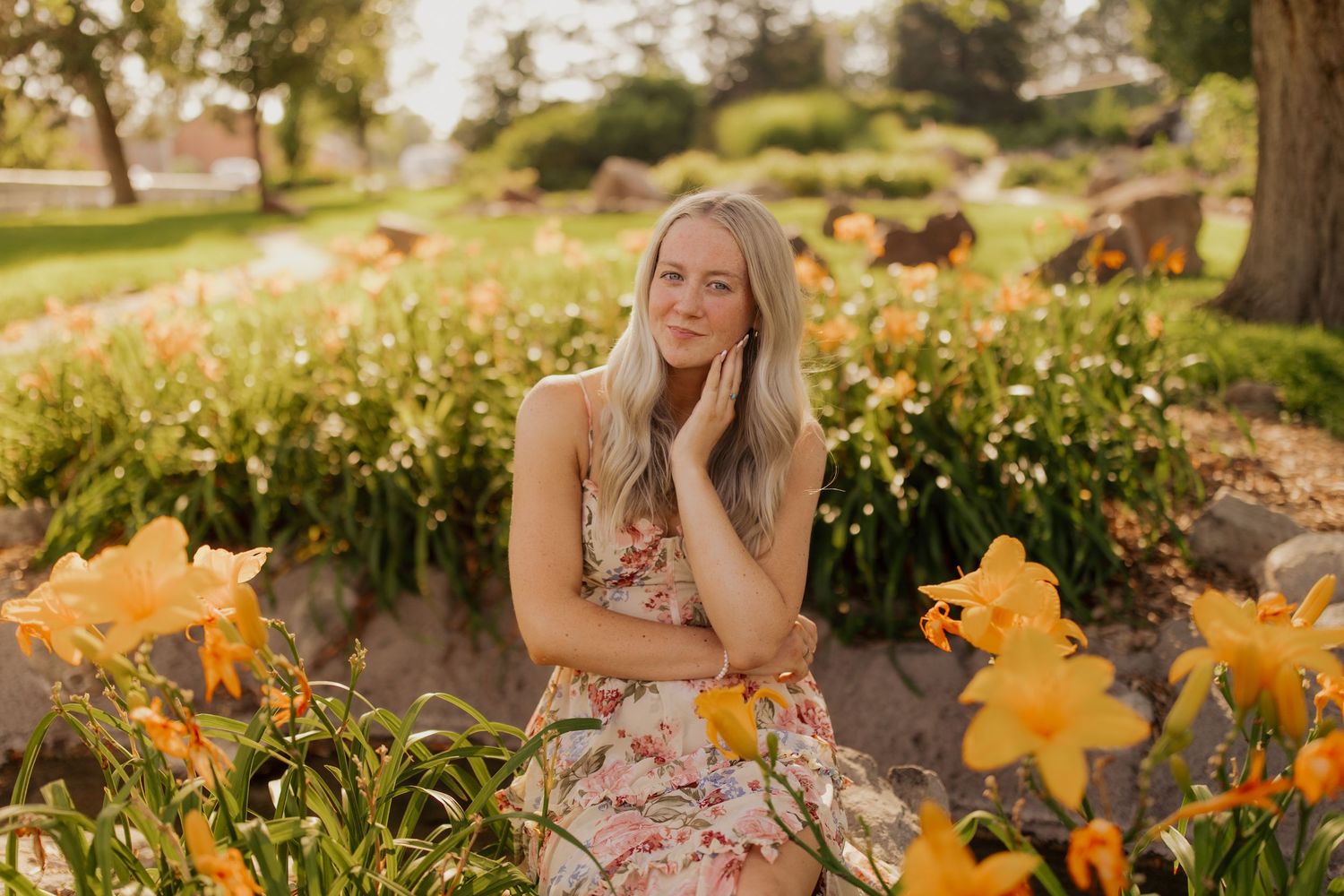 Natural outdoor portrait session among blooming yellow daylilies in a garden setting.