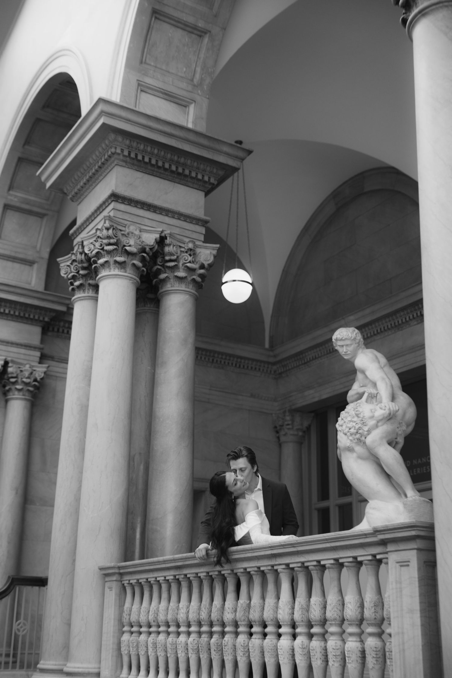 Classical architecture interior with ornate columns and sculptures in a museum or gallery space.
