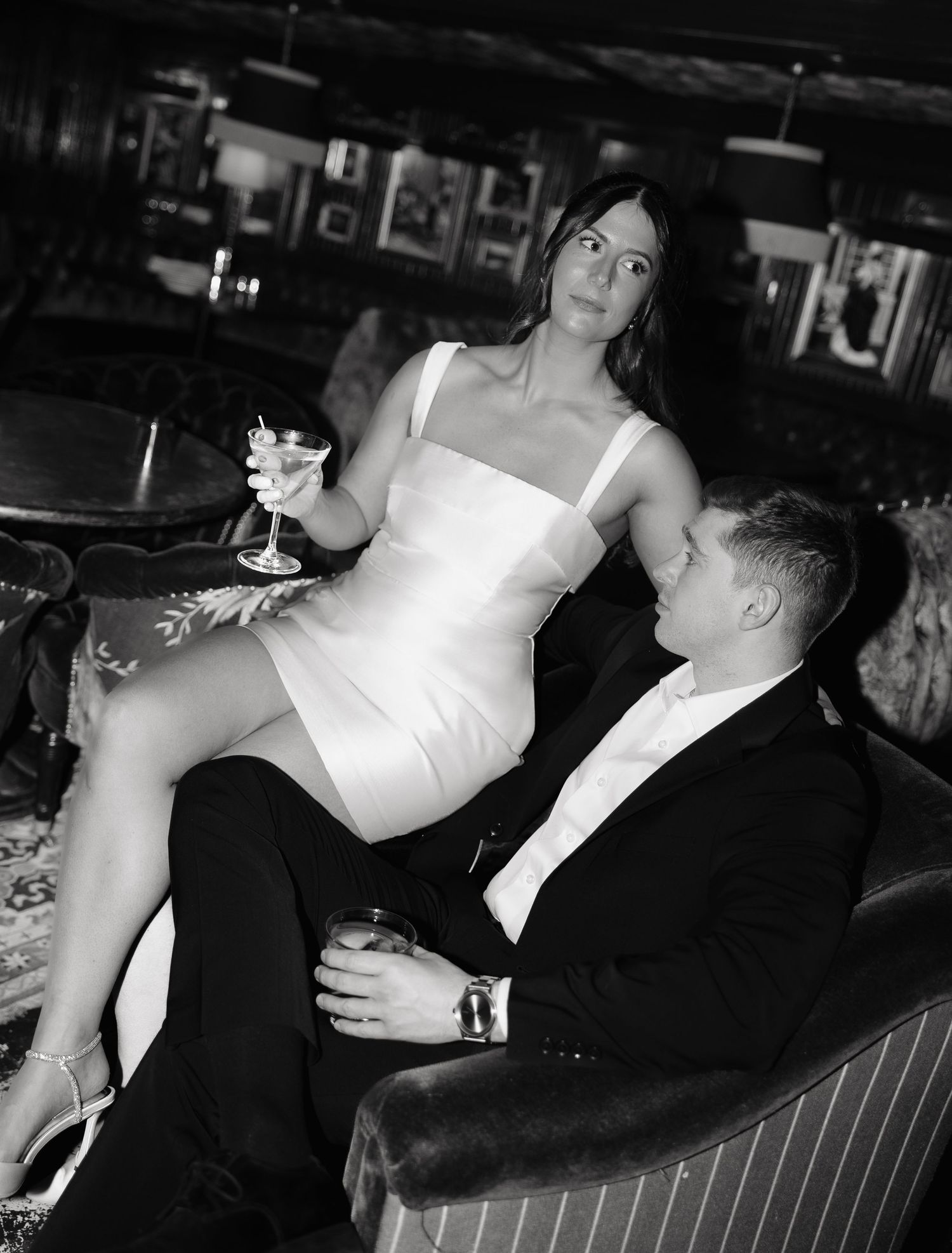 A couple in formal attire sharing an intimate dance moment in black and white photography.