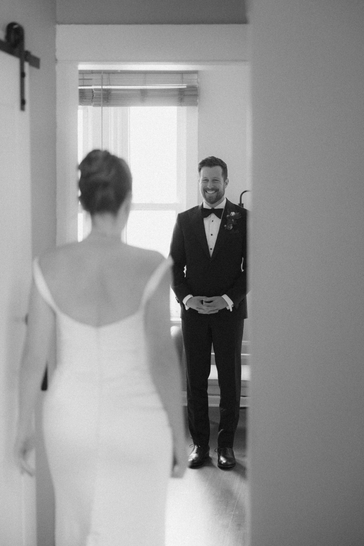Black and white photo sequence showing a first look moment between a bride in white and groom in tuxedo.