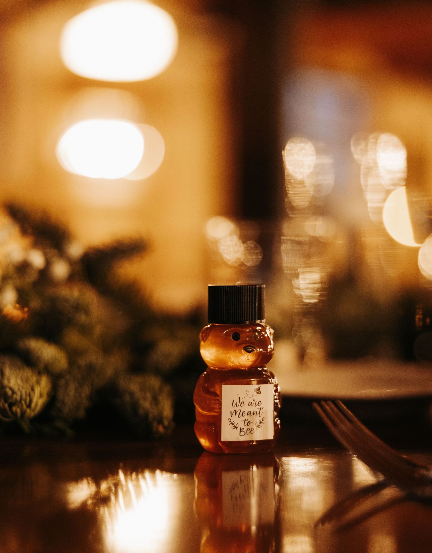Warm glowing lights create a cozy ambiance with glass jars and evergreen decorations in a romantic setting.