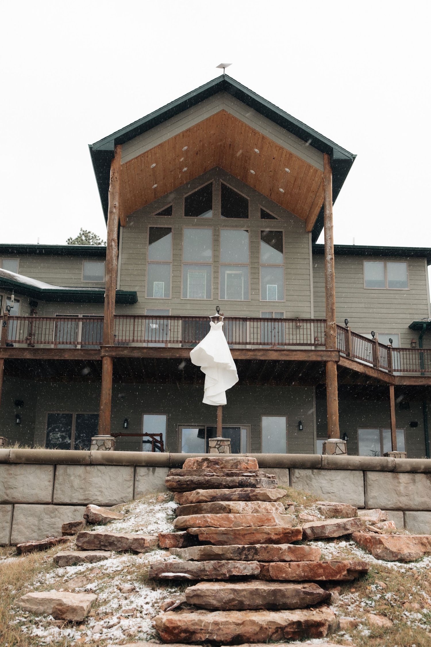 Row of modern cabin-style buildings with wooden decks on rocky terrain.
