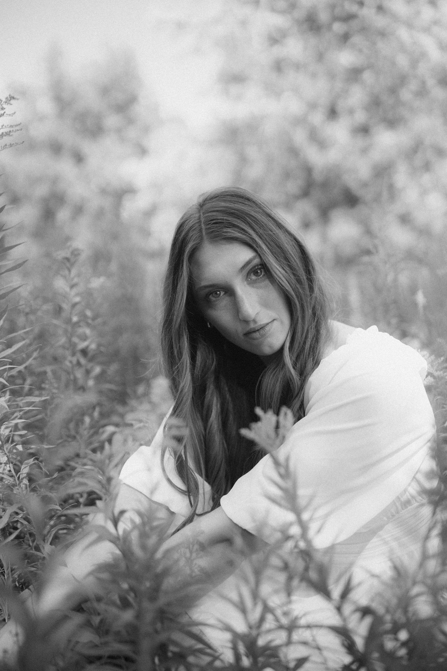 Dreamy black and white portrait surrounded by wildflowers and natural light.