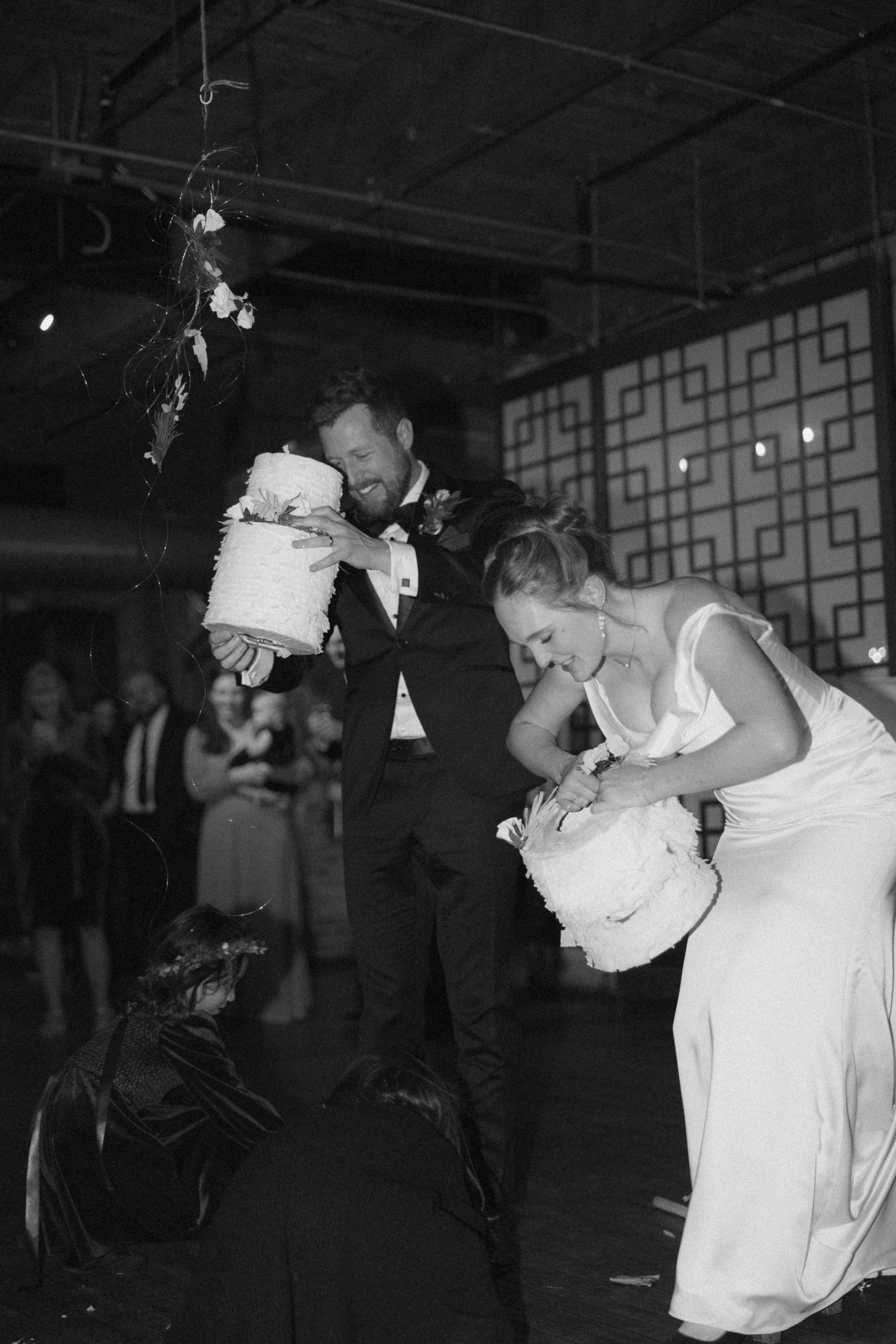 A couple in formal attire sharing a romantic dance moment on a dimly lit dance floor.