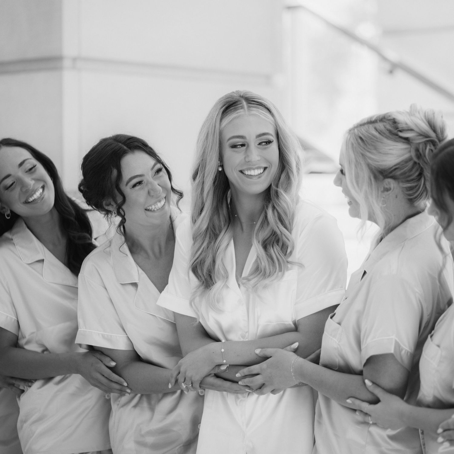 Group of people in white button-down shirts laughing and having fun together in black and white photo.