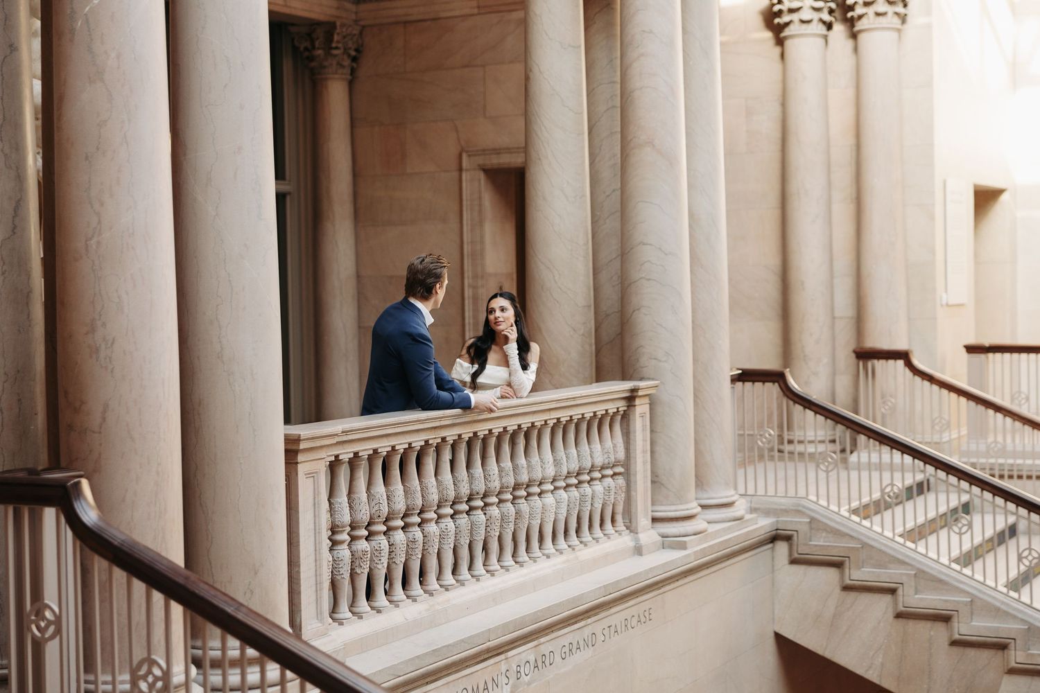 An elegant colonnade with white marble pillars and arched ceilings in a historic building.