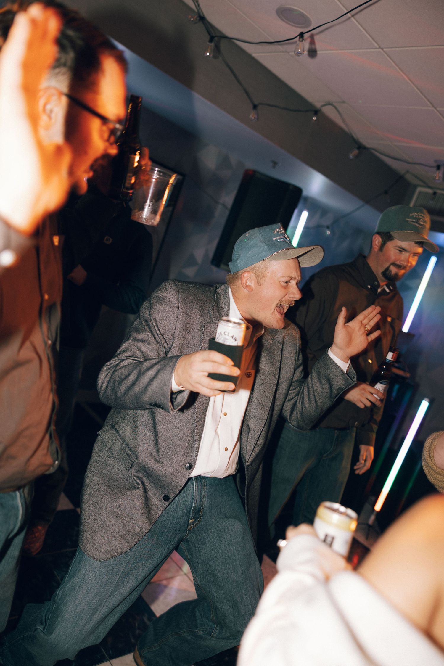 People dancing and celebrating at a lively party with drinks in hand.