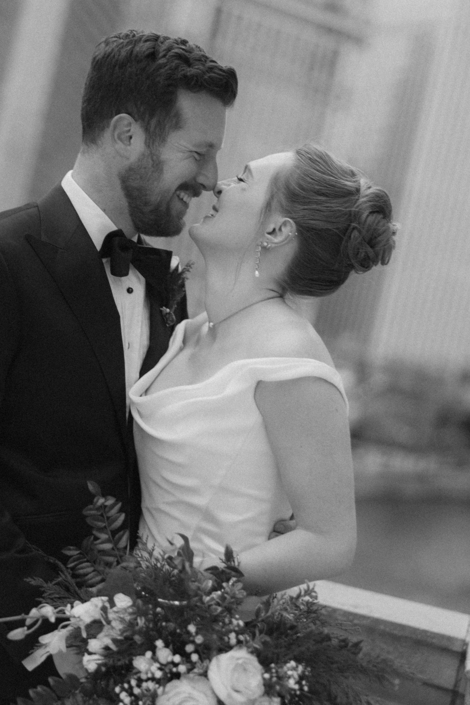 A romantic black and white wedding photo series showing tender moments between newlyweds with elegant floral bouquet.