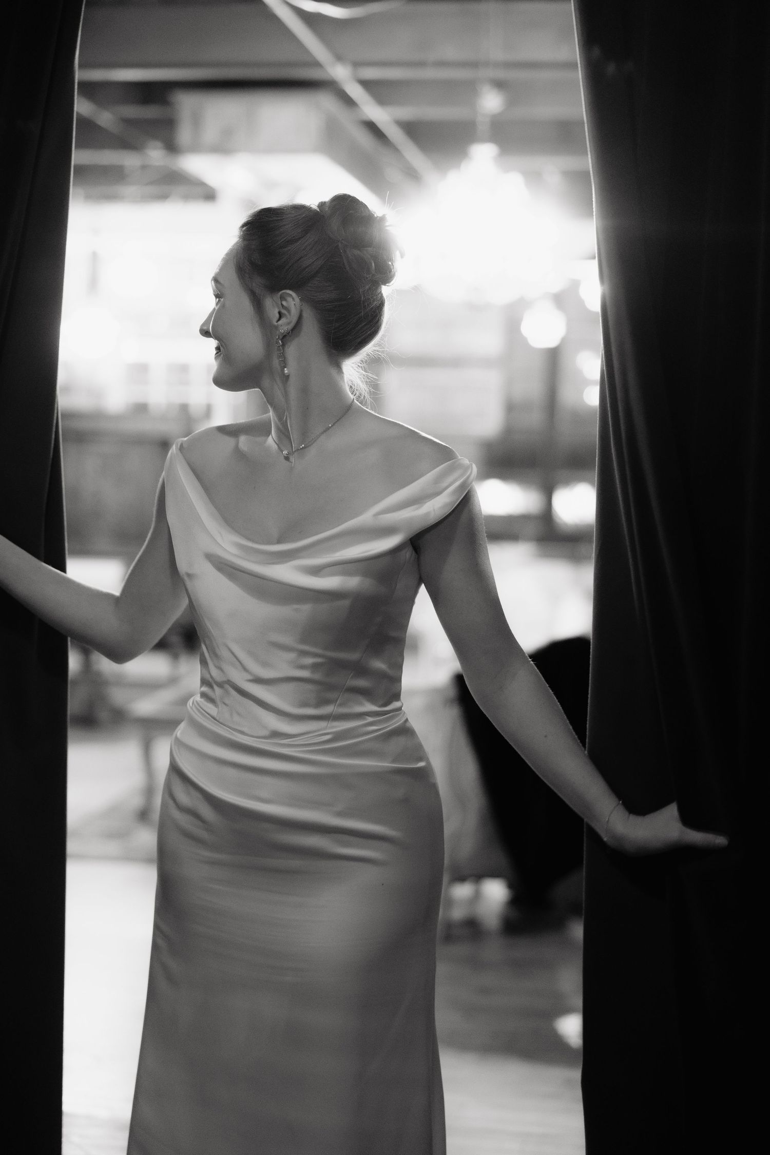 A woman in an elegant white dress poses gracefully in a series of black and white photographs.