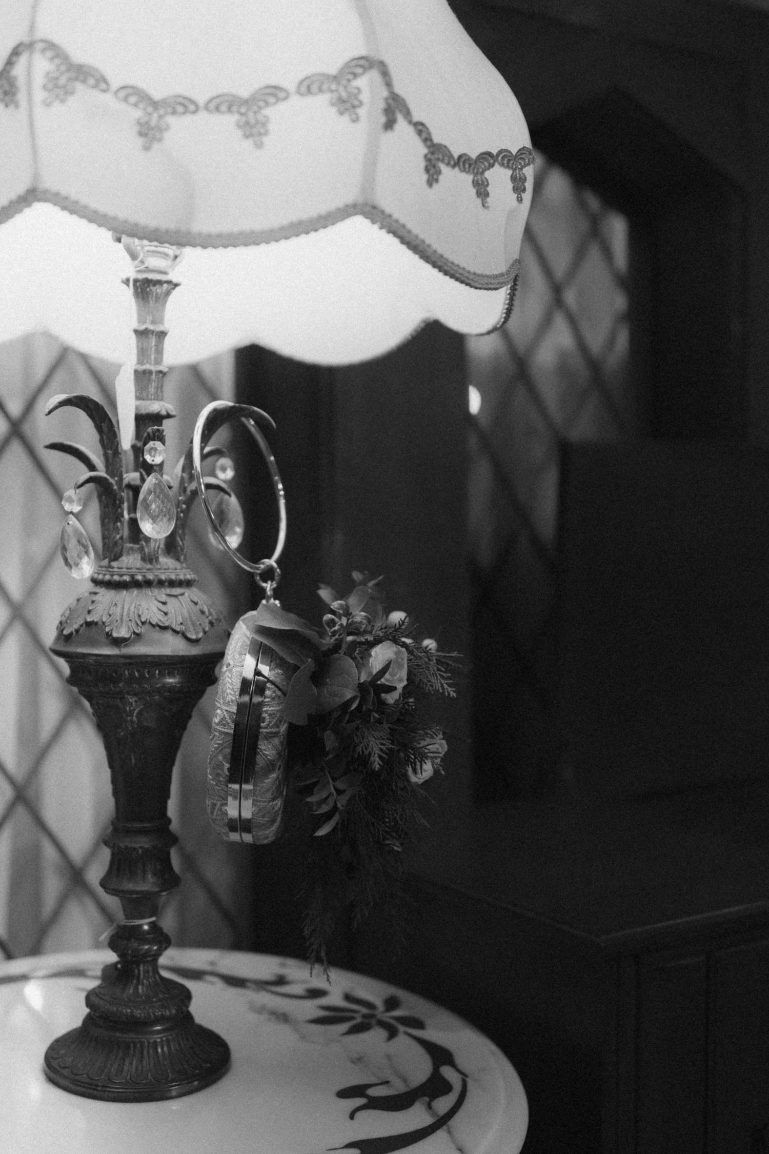 Vintage black and white photograph of antique table lamps with ornate bases and shades creating moody lighting.
