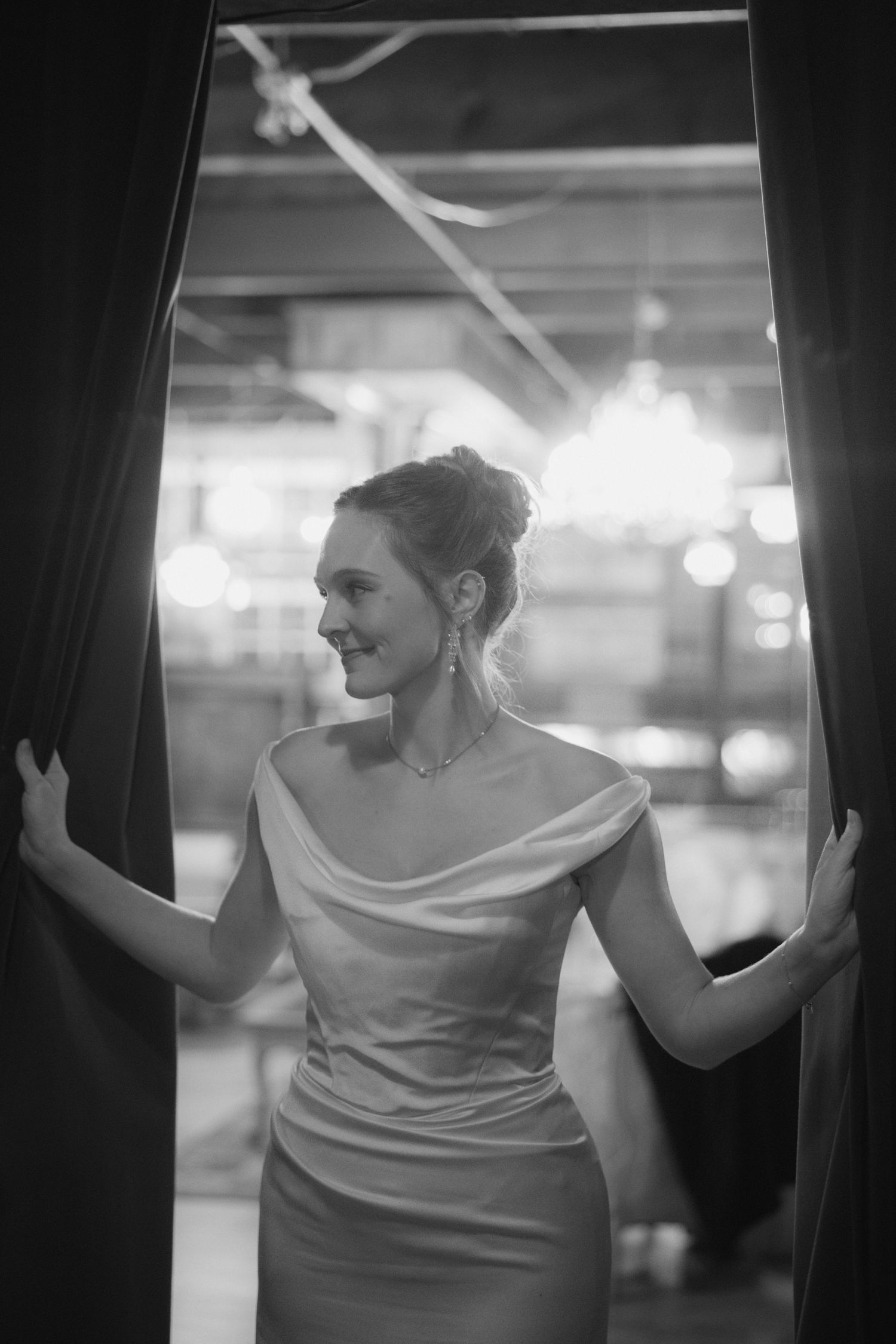 A person in an elegant white dress poses gracefully against a dark background in a series of black and white photographs.