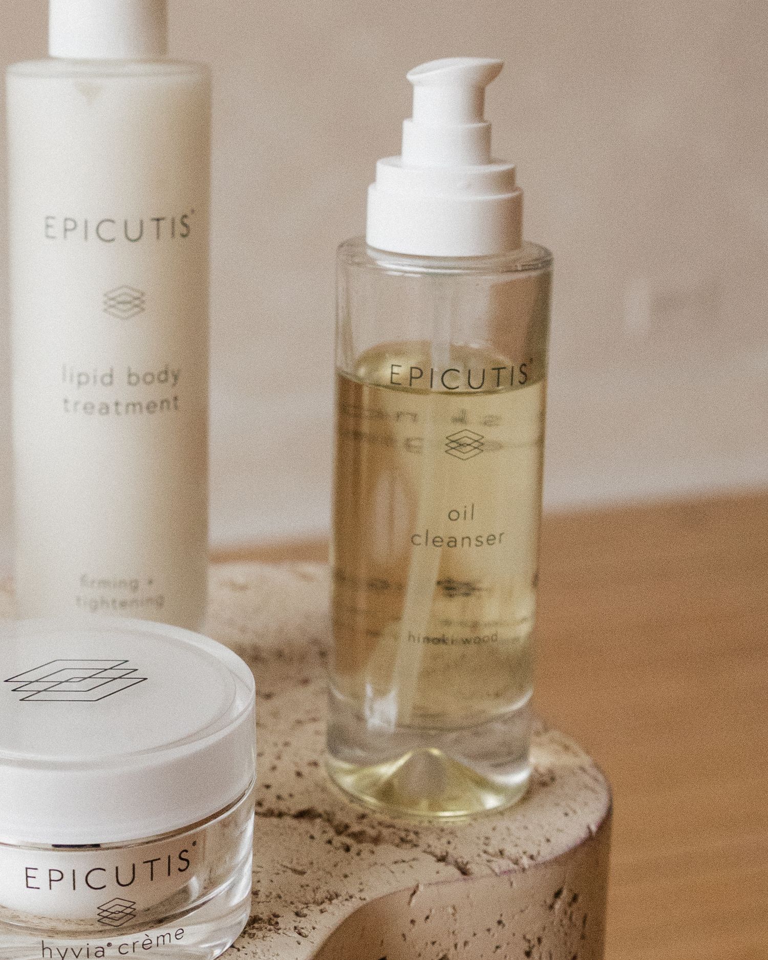 Collection of Epicutis skincare products including body treatment and oil cleanser on textured surface.