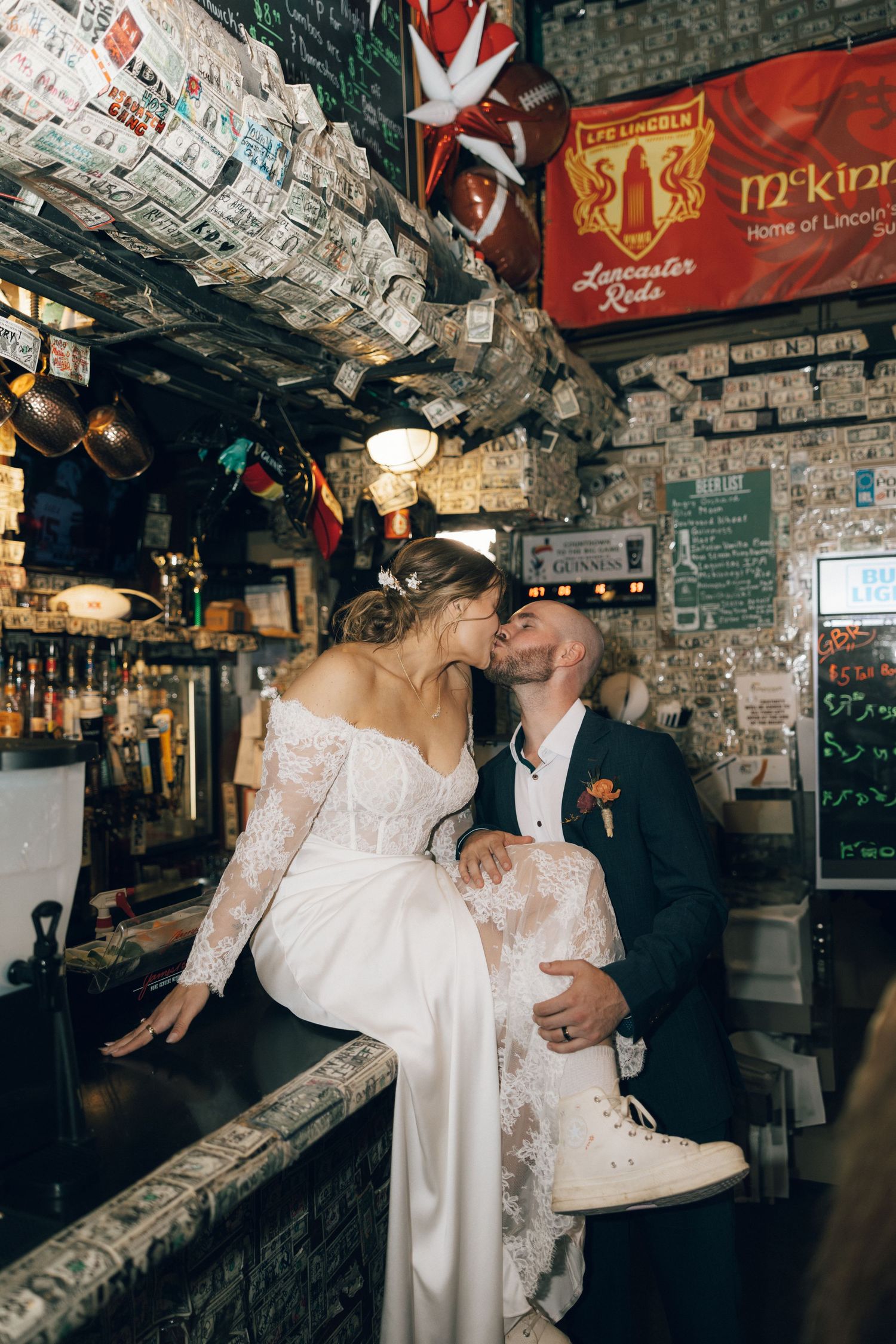 Couple dancing together in a bar decorated with dollar bills on the walls and ceiling.