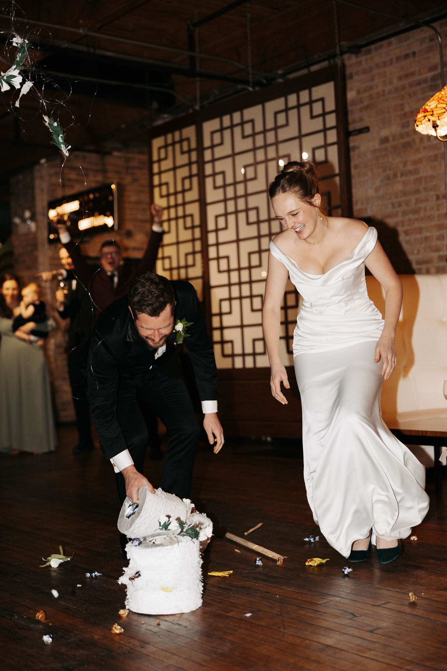 A bride and groom share a playful moment on the dance floor at their wedding reception.