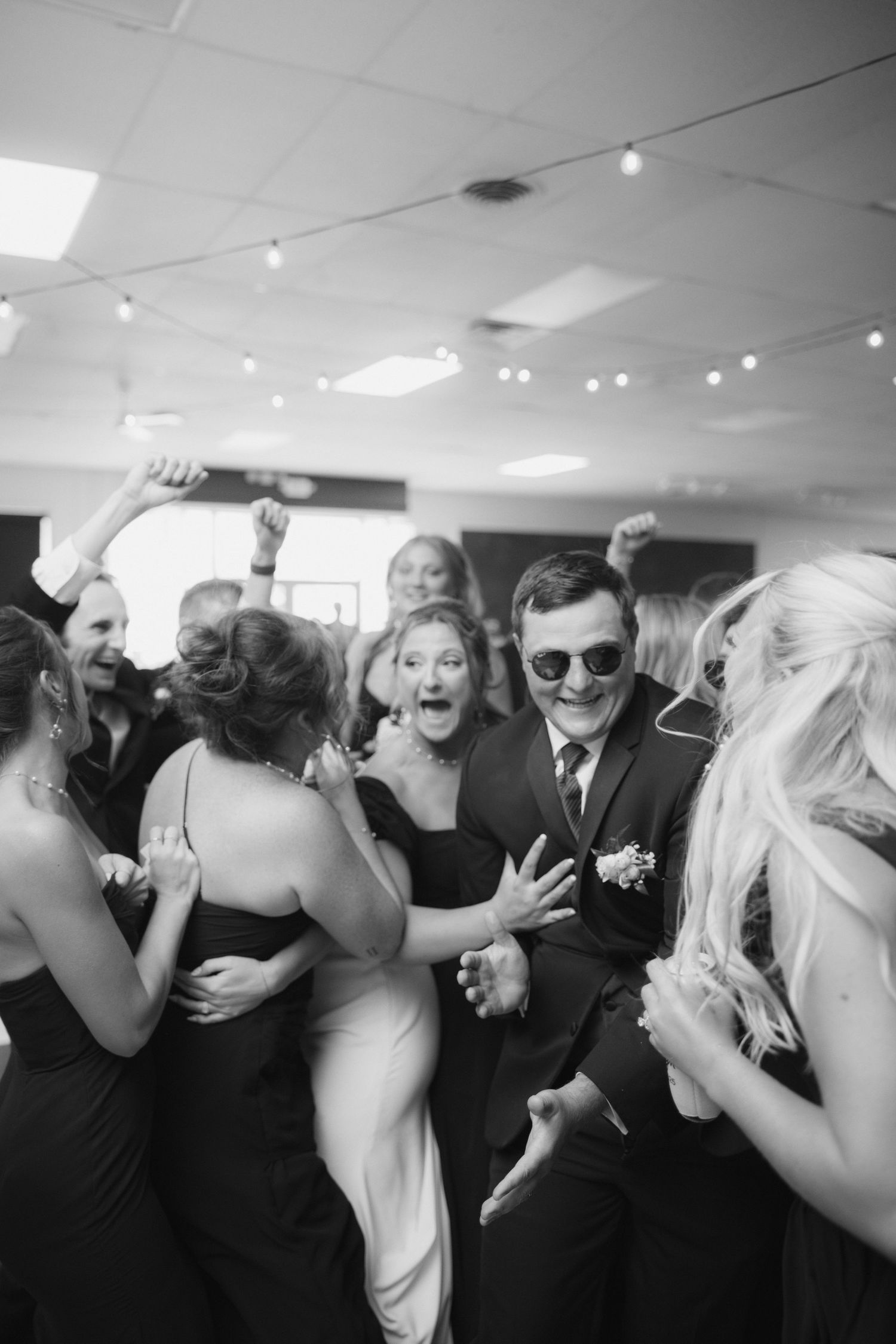 Joyful celebration and dancing at an indoor wedding reception.