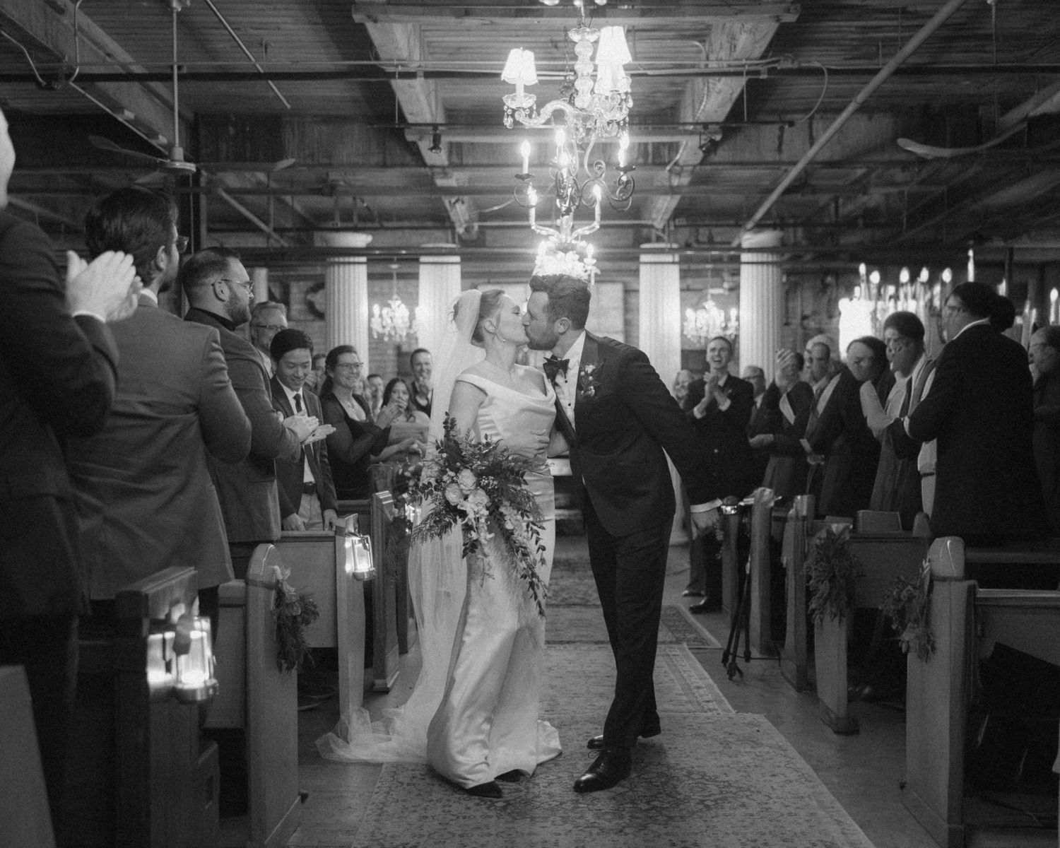 Black and white wedding reception photos show couples dancing on a ballroom floor under elegant chandeliers.