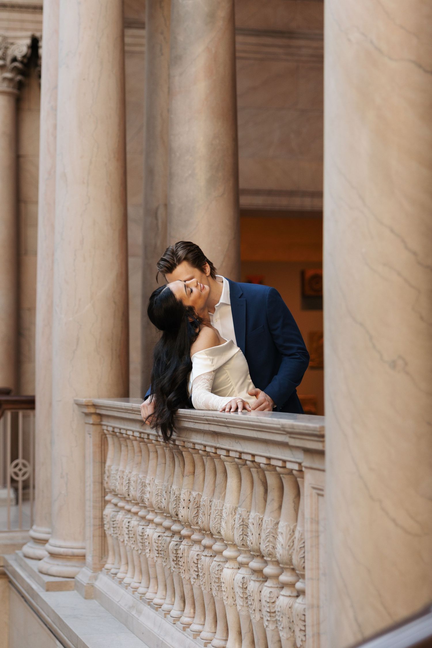 A romantic moment captured in a classical colonnade with marble pillars.