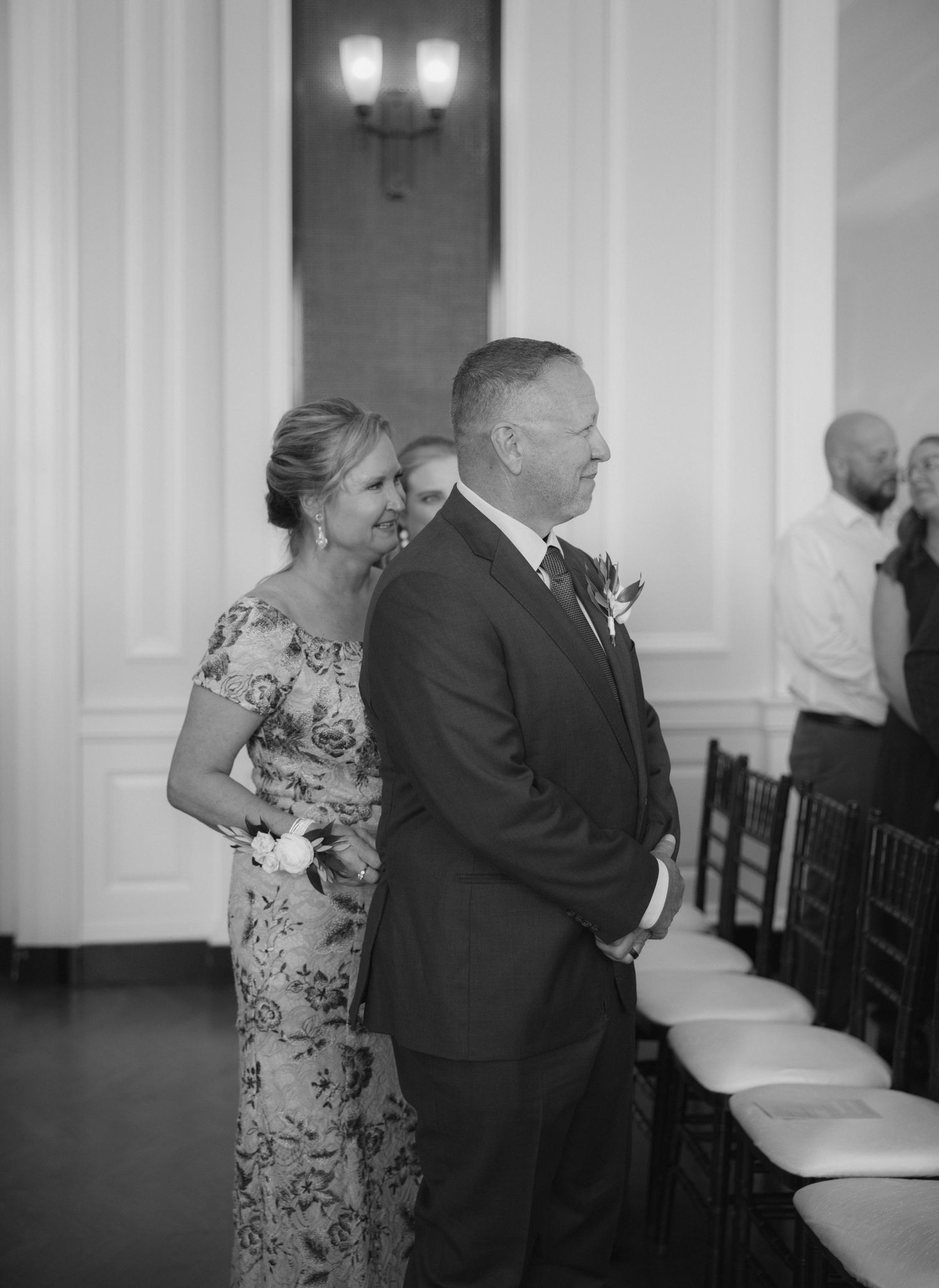 Black and white wedding photos show couple dancing and embracing in an elegant indoor venue.