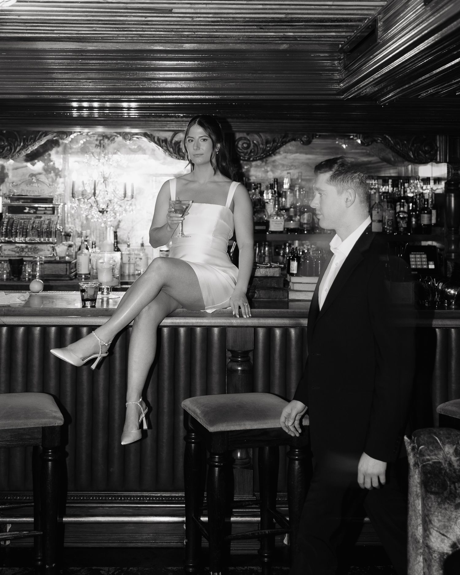A series of black and white photographs showing people in formal attire interacting at what appears to be a bar setting.