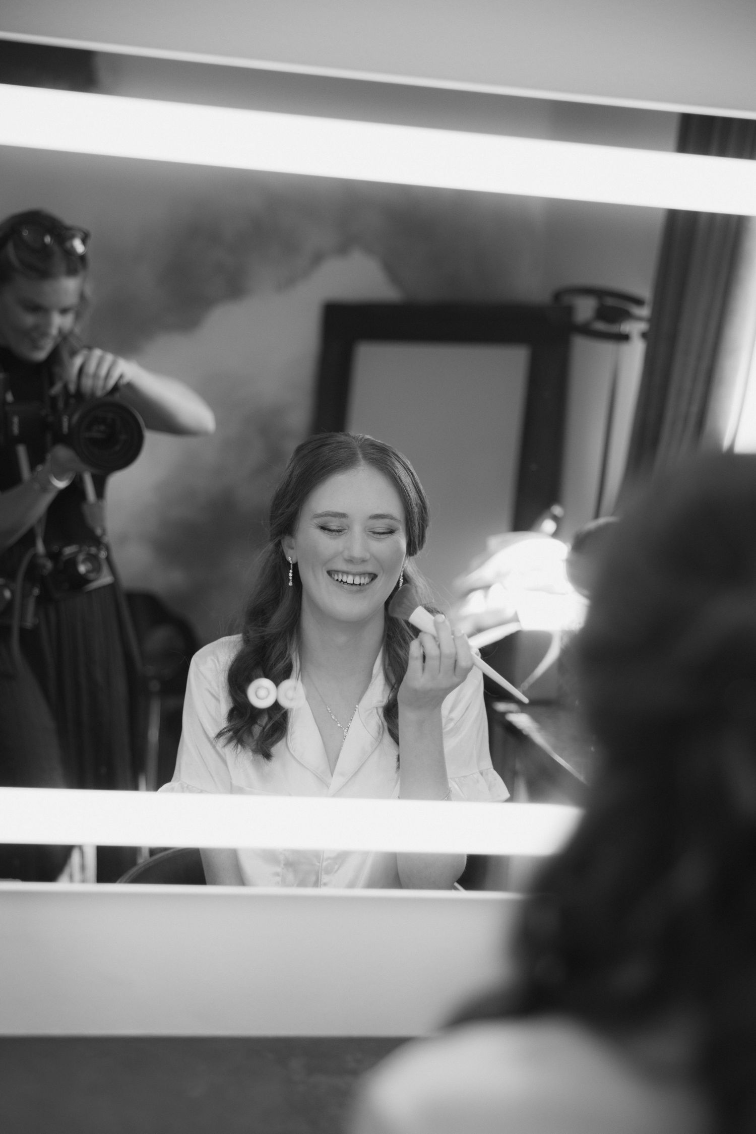 Black and white wedding preparation photos show a bride getting ready in a candid series of emotional moments.