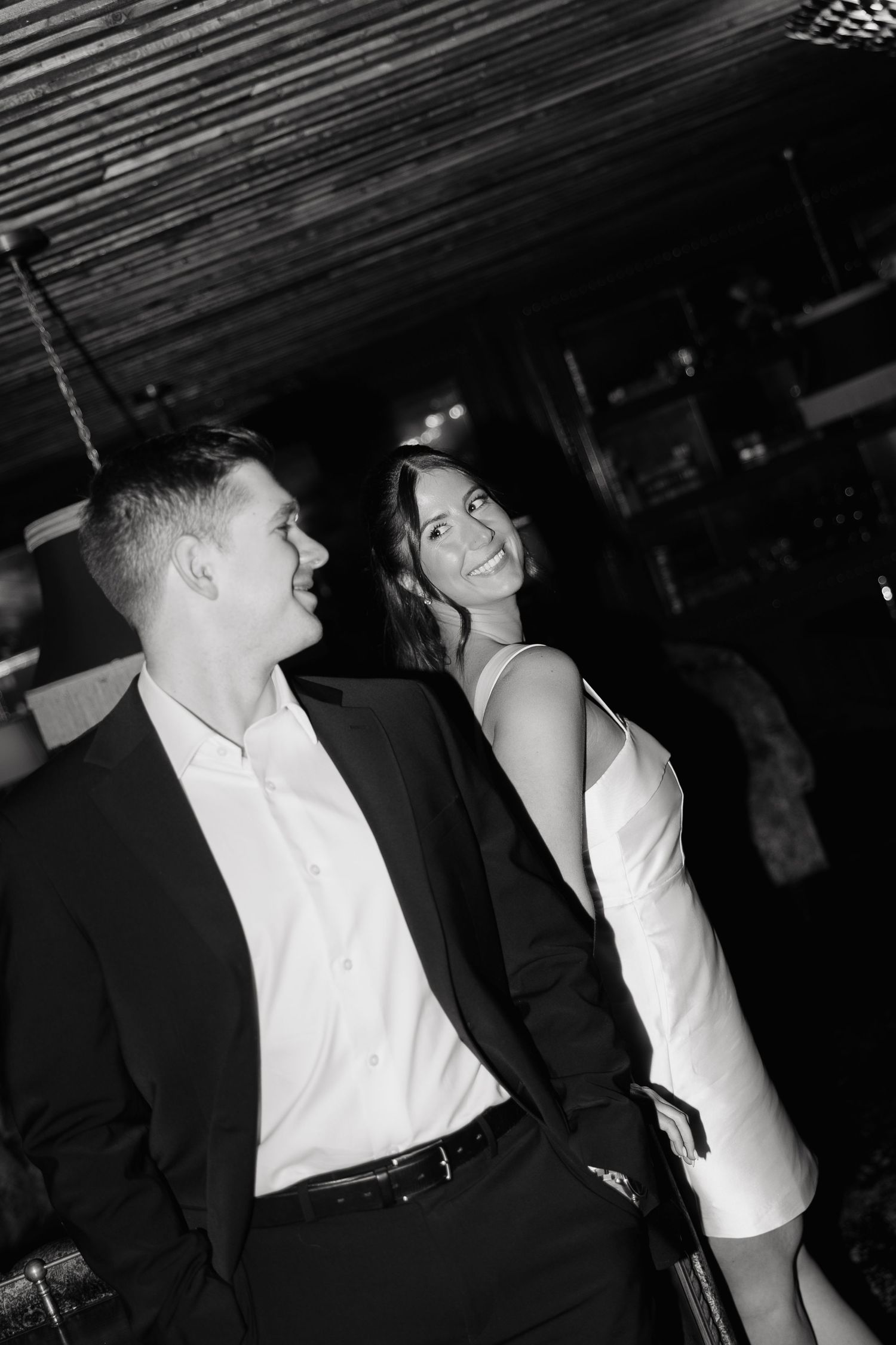 Black and white photos show two people in formal attire having an animated conversation at a social event.
