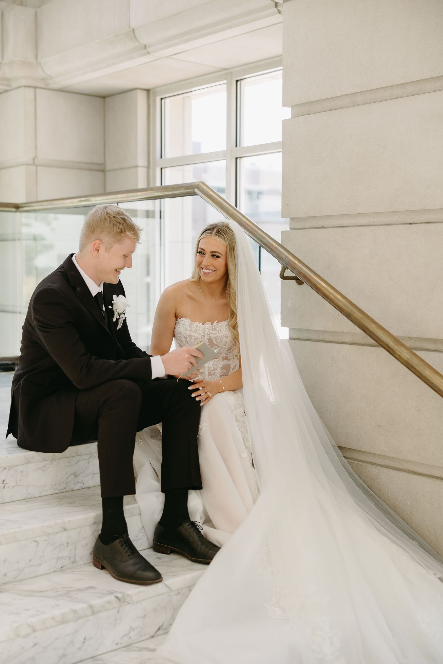 Intimate wedding photos captured on a marble staircase with natural lighting.