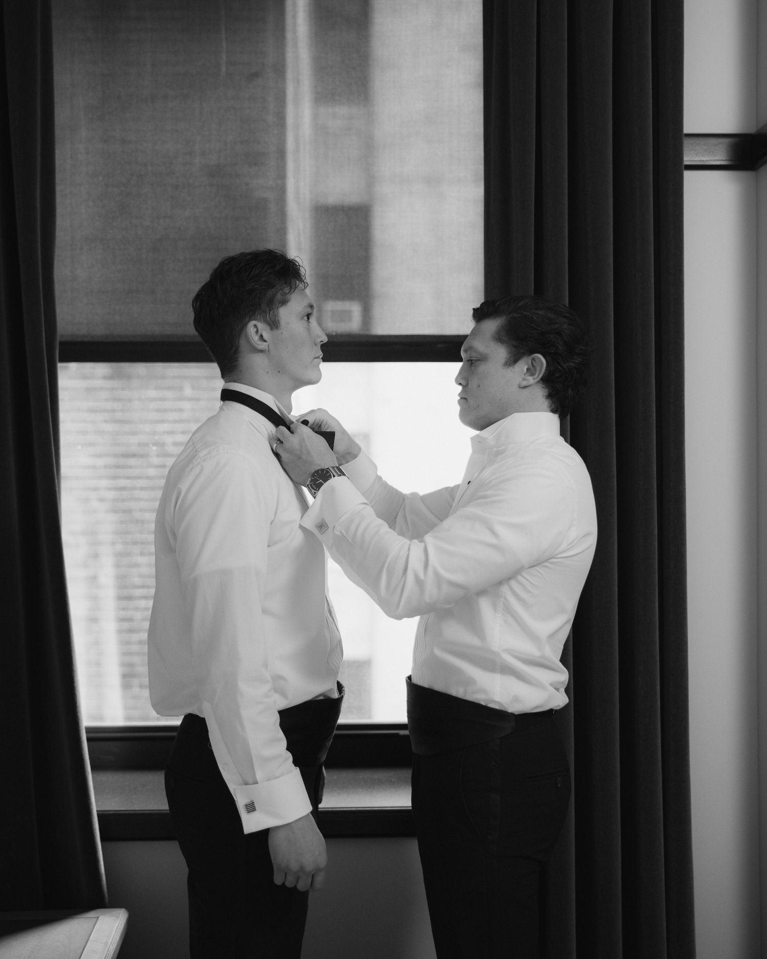 Black and white photos showing men in white shirts adjusting formal attire before an event.