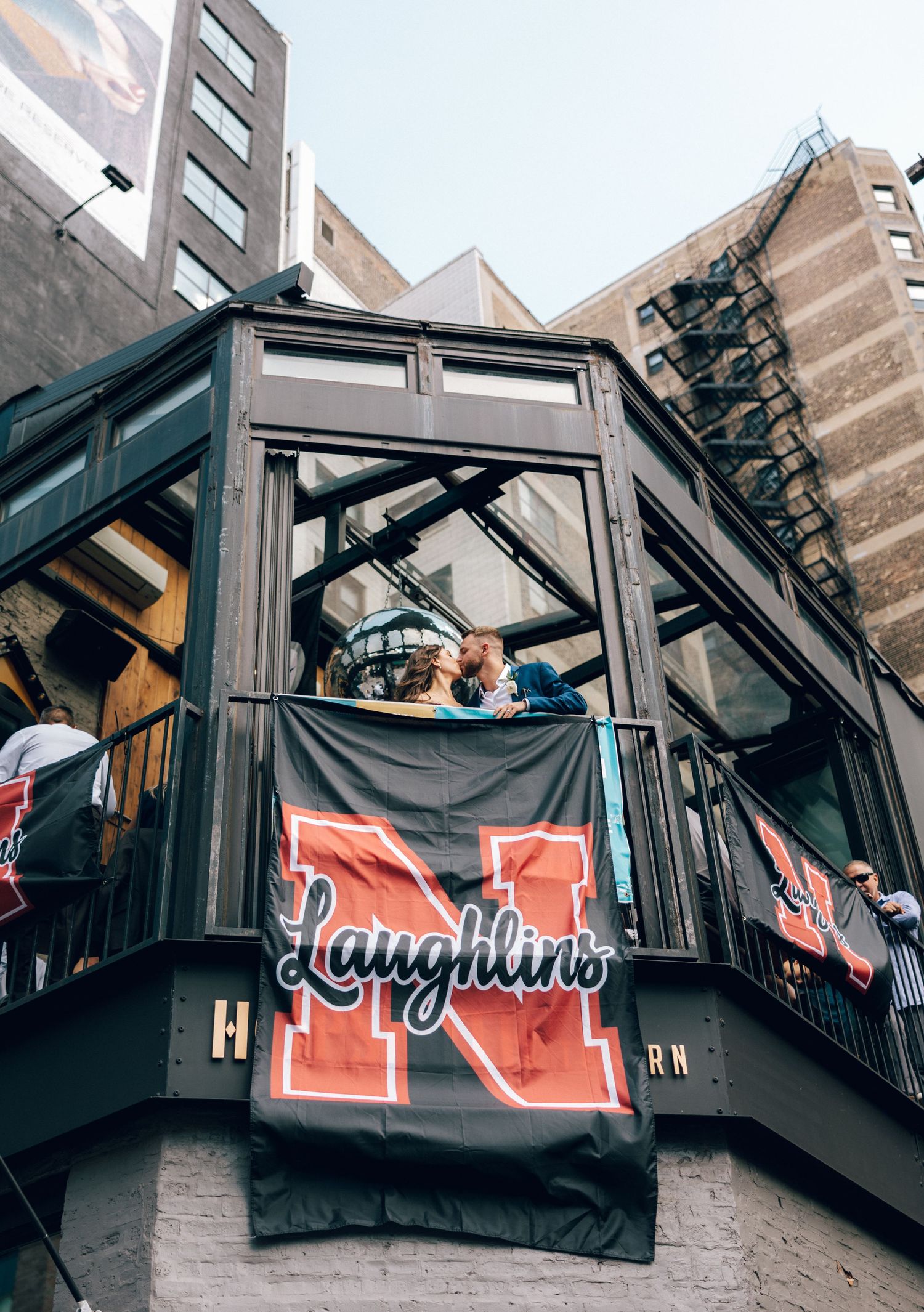 A sequence of photos showing a black and red neon sign being installed on an outdoor balcony railing.