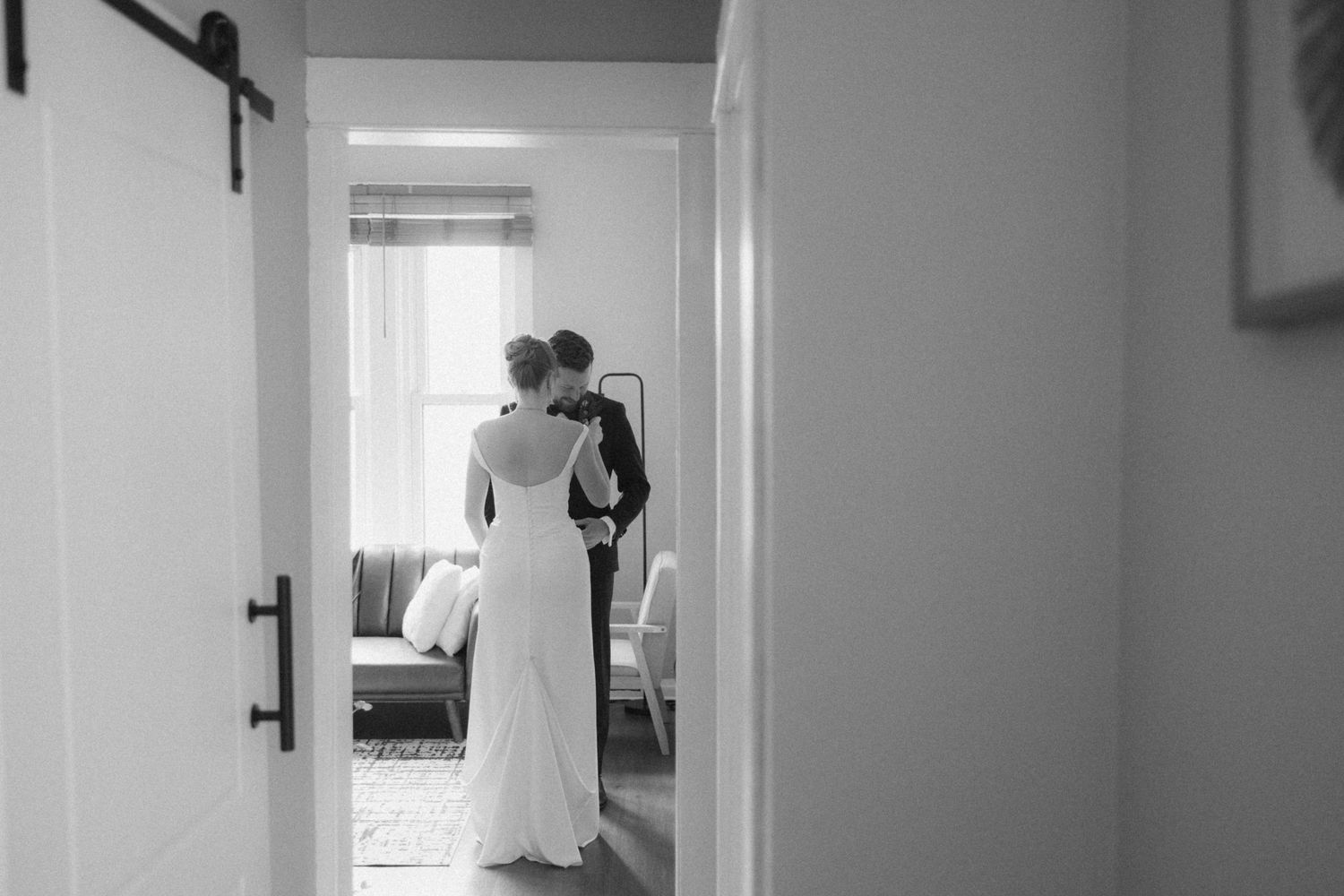 Black and white photo series showing someone moving through doorways in a minimalist interior space.