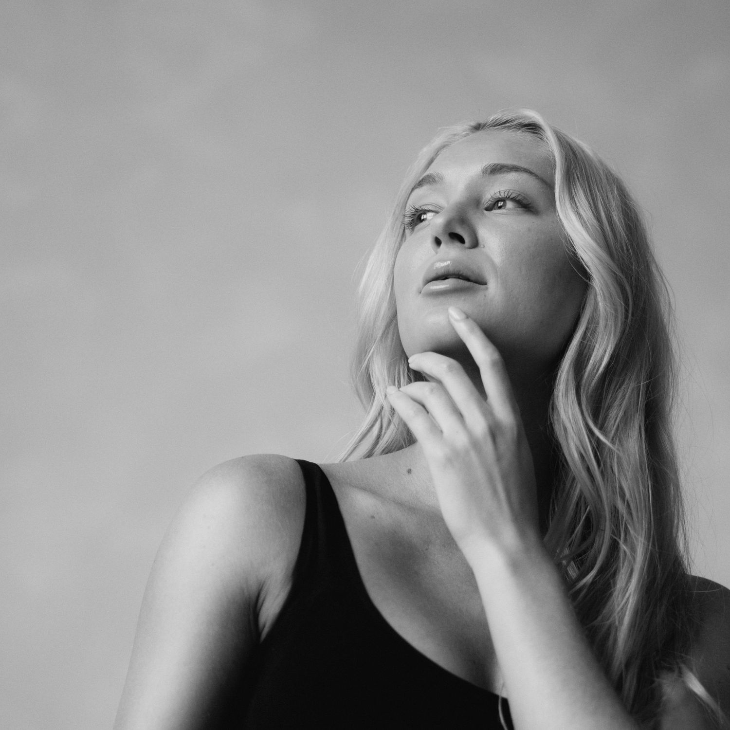 Black and white artistic portrait series showing a person with blonde hair in various dramatic poses.