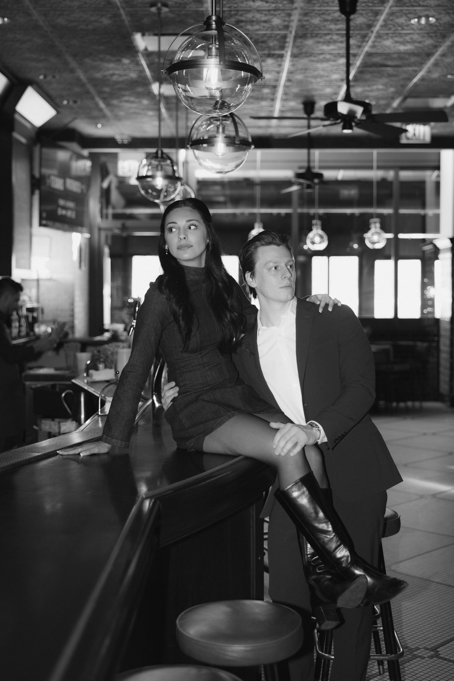 A black and white photo series showing a couple dancing together in an industrial-style space with exposed ceiling.