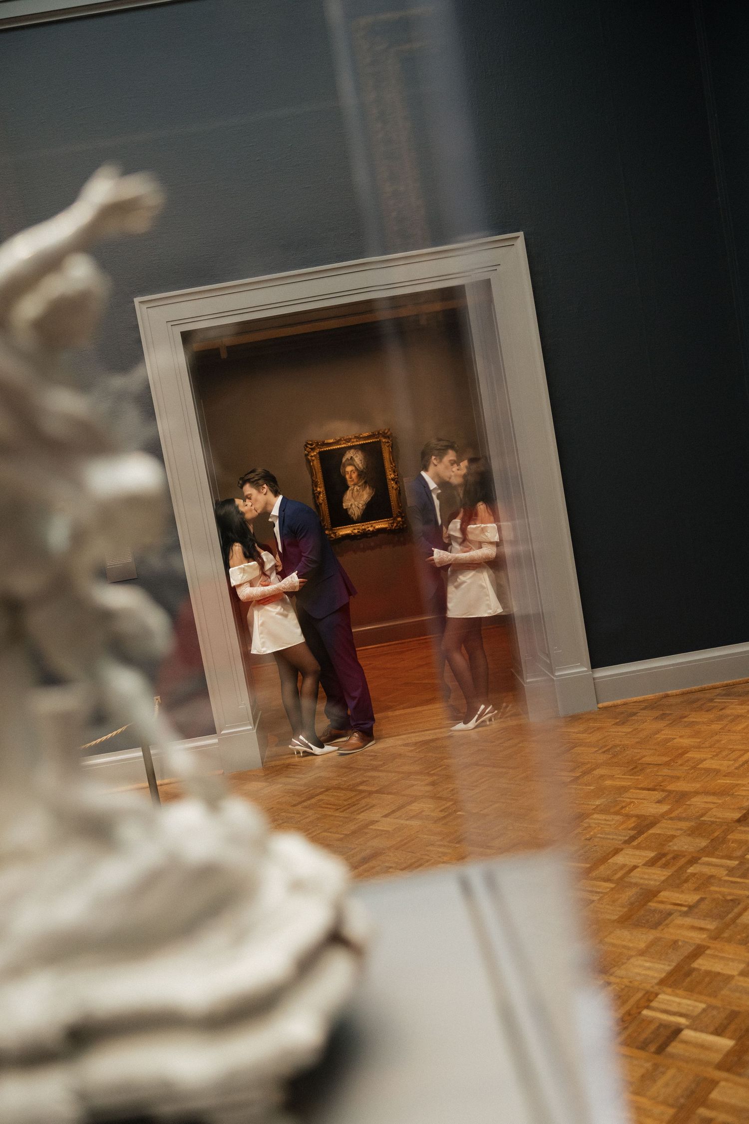 Artistic museum engagement photos with blurred sculptures in the foreground.
