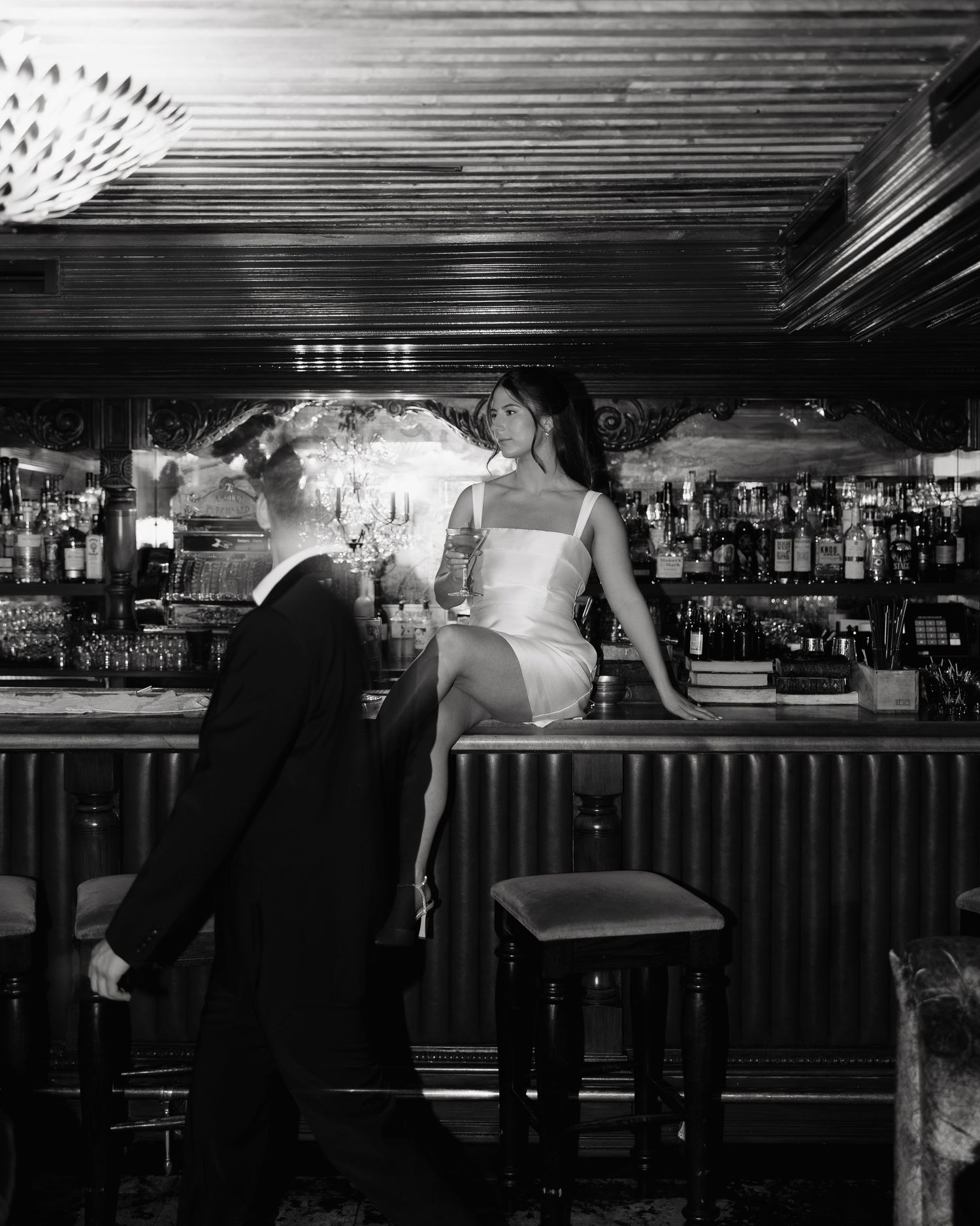 A series of black and white photographs showing patrons at a bar counter in a dimly lit establishment.