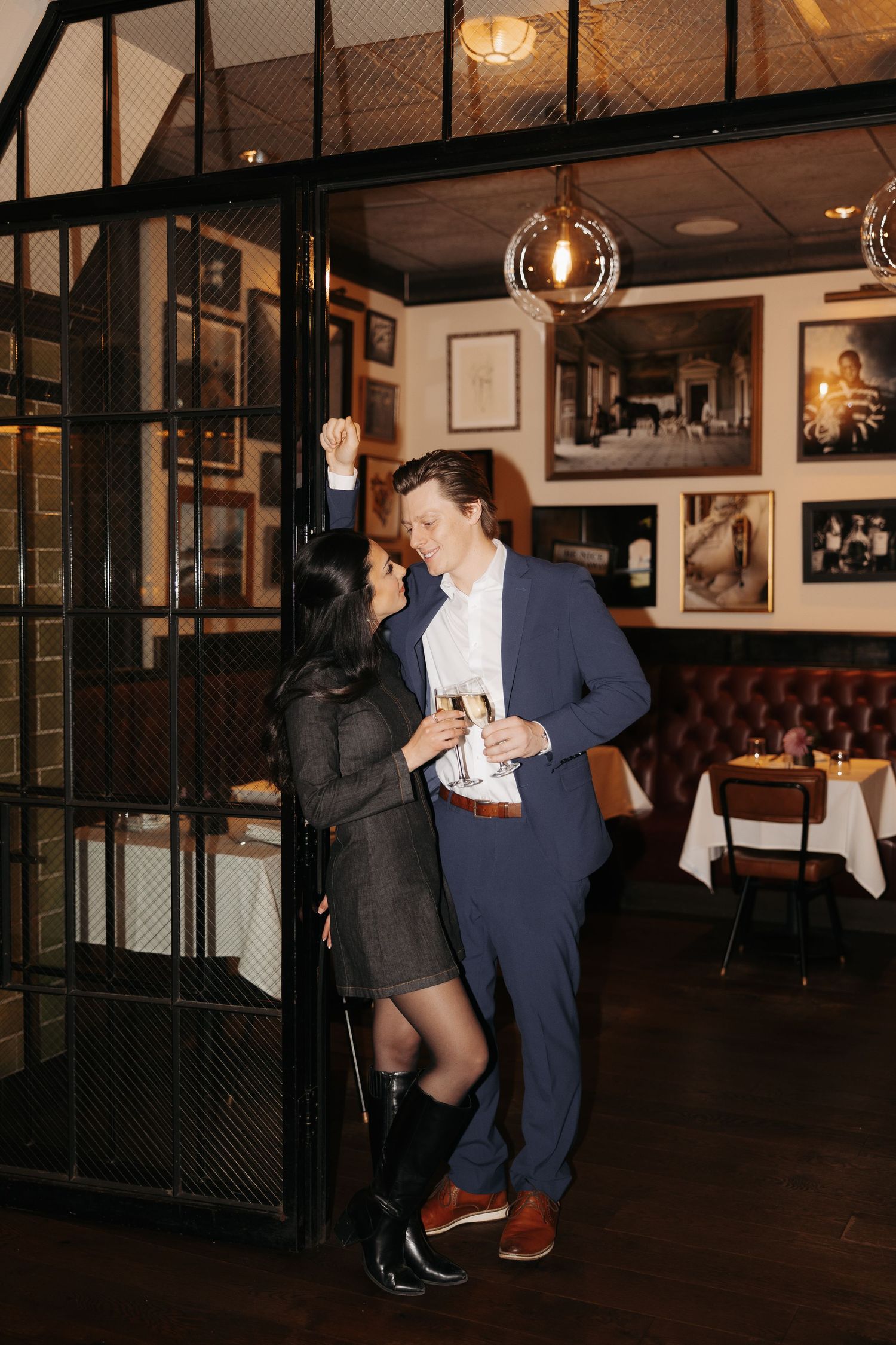 A couple dances together in a dimly lit restaurant with vintage decor.