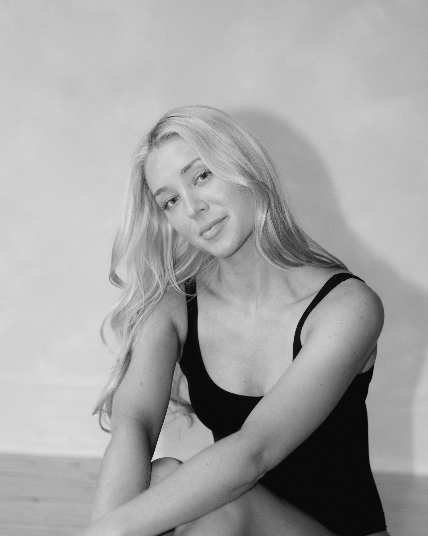 Black and white portrait series showing artistic poses in a minimalist studio setting.