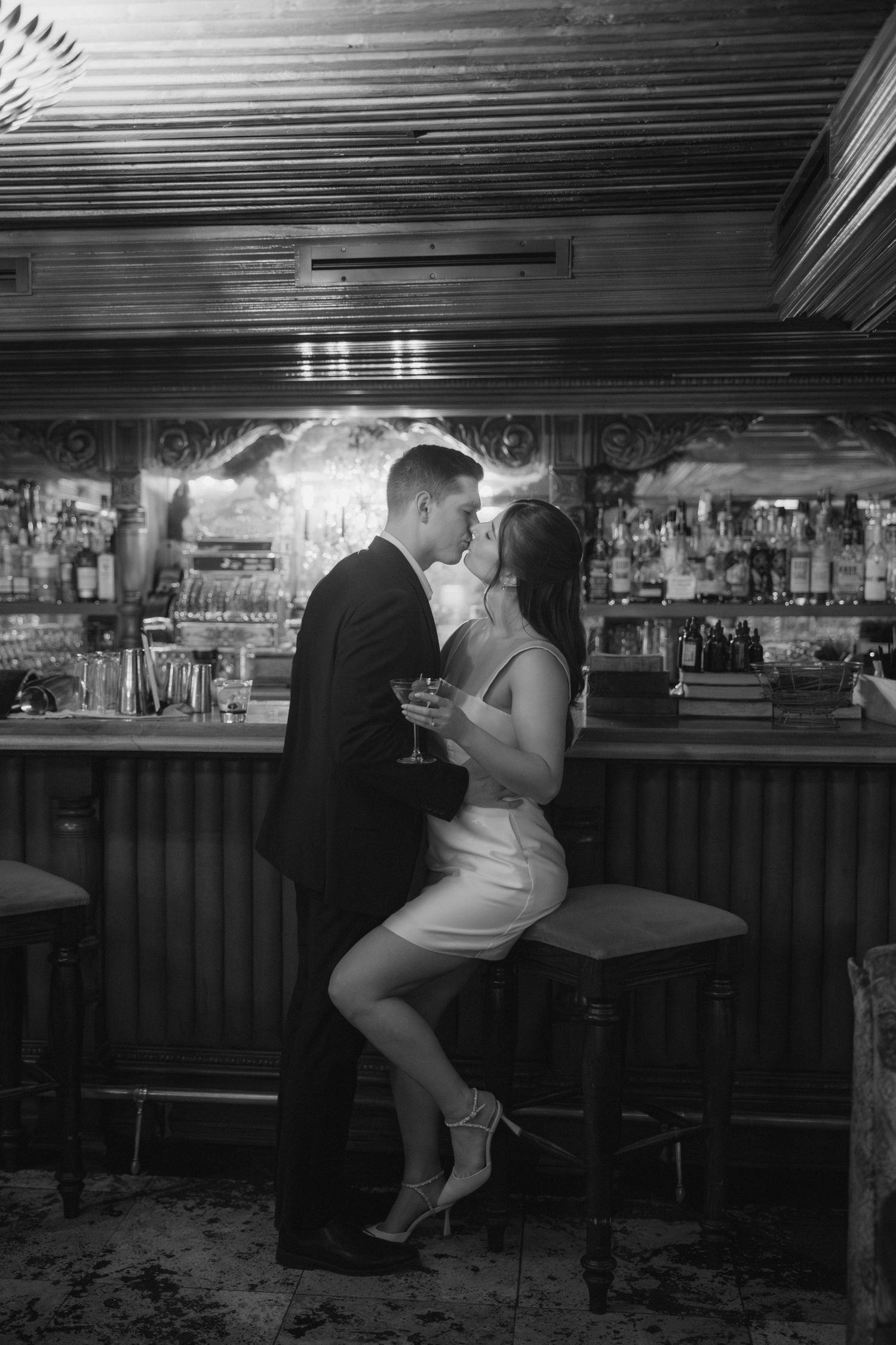 A sequence of black and white photographs showing a person sitting at a dimly lit bar counter in different poses.