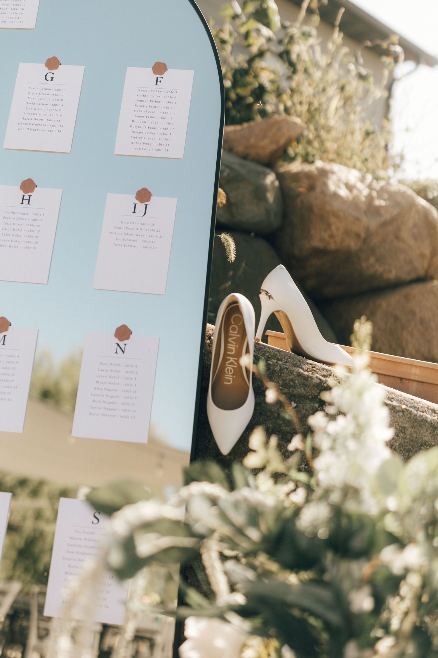 Light blue seating chart display with white cards and floral decorations.