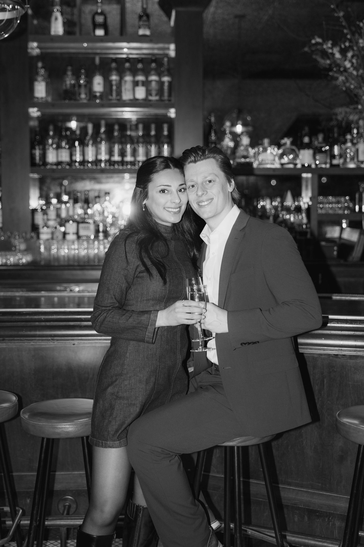 A black and white photo series showing a couple enjoying drinks together at a dimly lit bar.