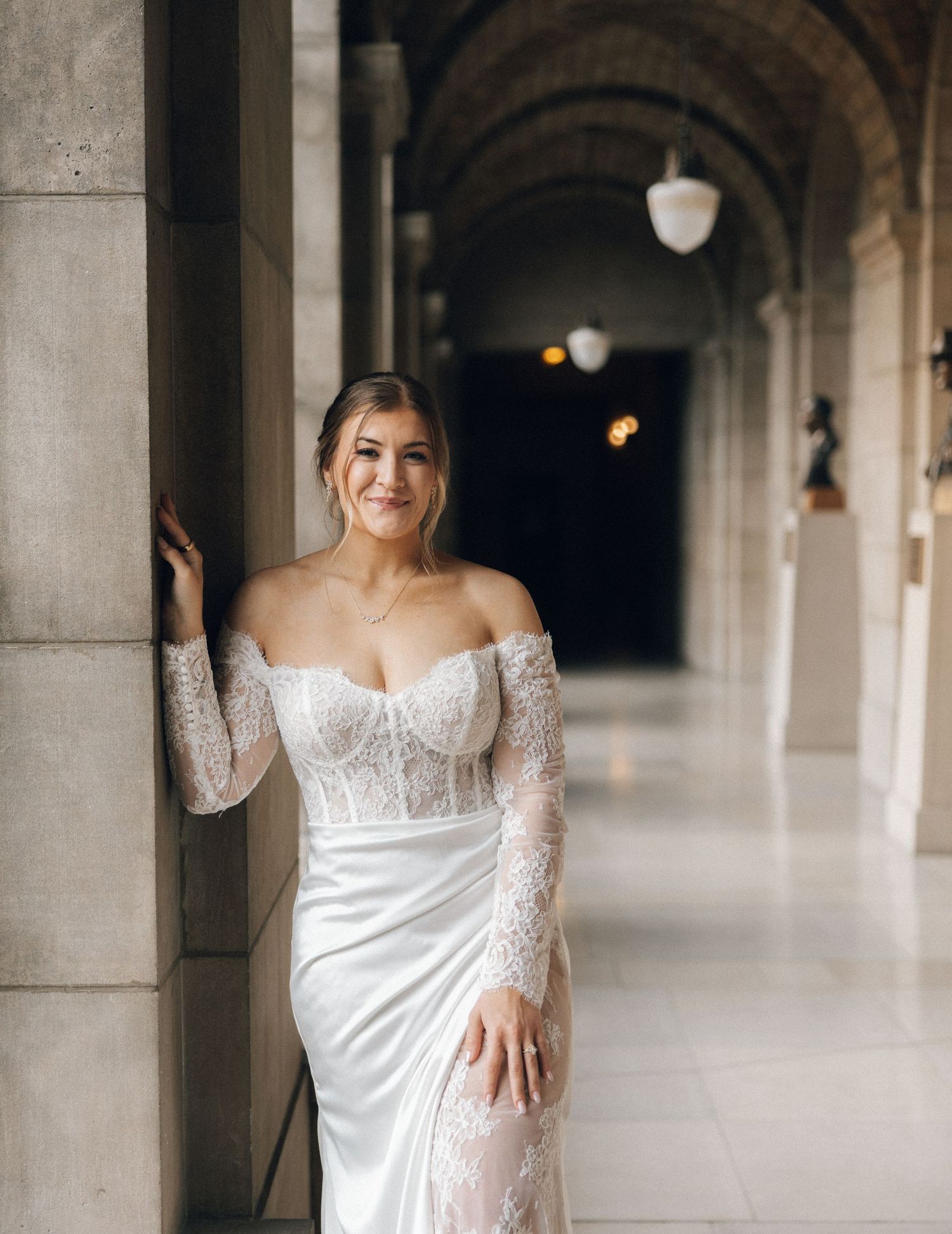Elegant bridal portraits in a columned hallway with natural light.