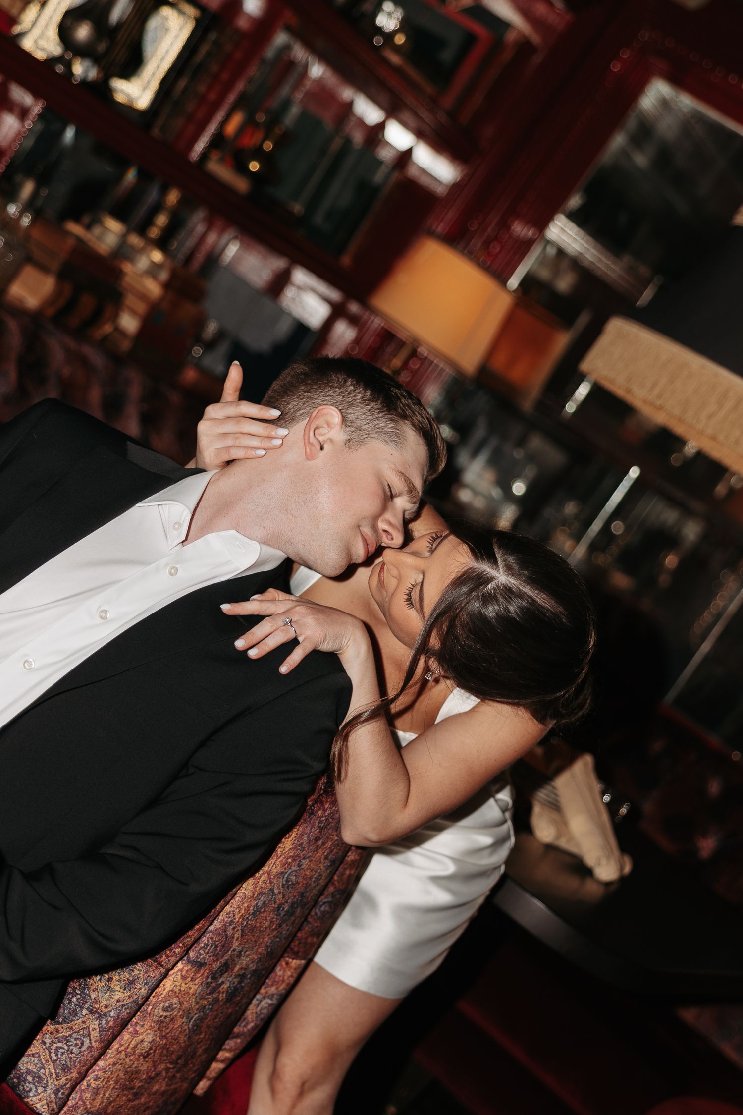 A couple shares a romantic dance dip moment in an intimate indoor setting.