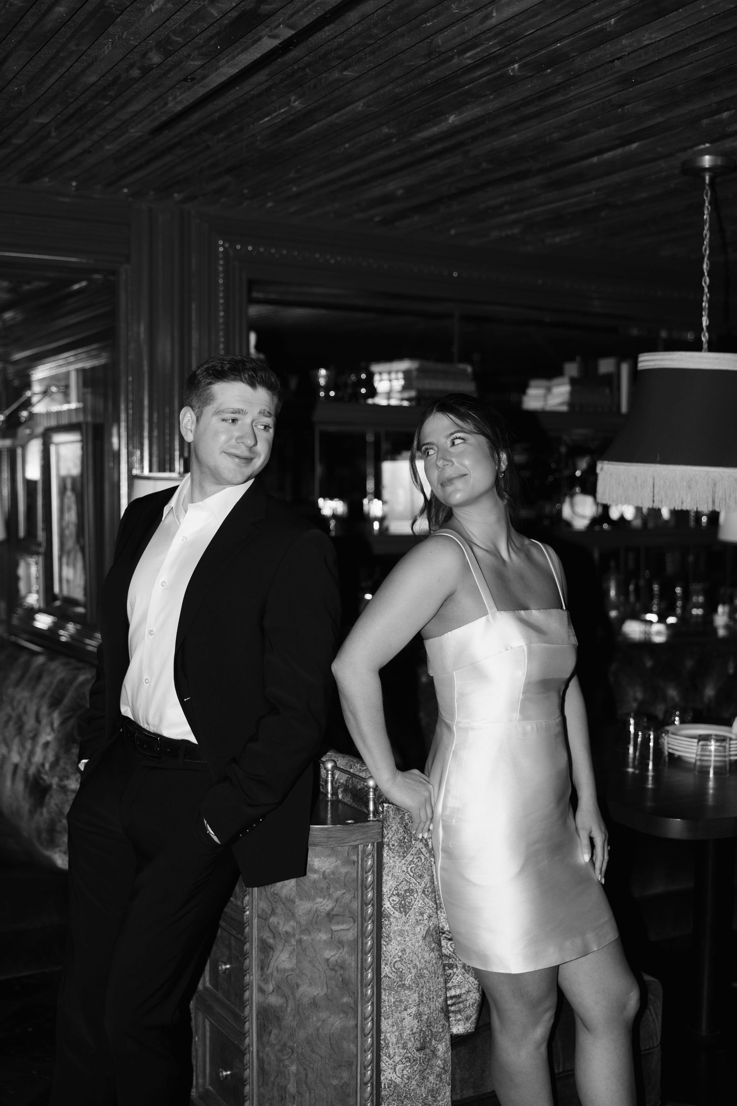 Two people in formal attire dance together in a dimly lit ballroom setting.