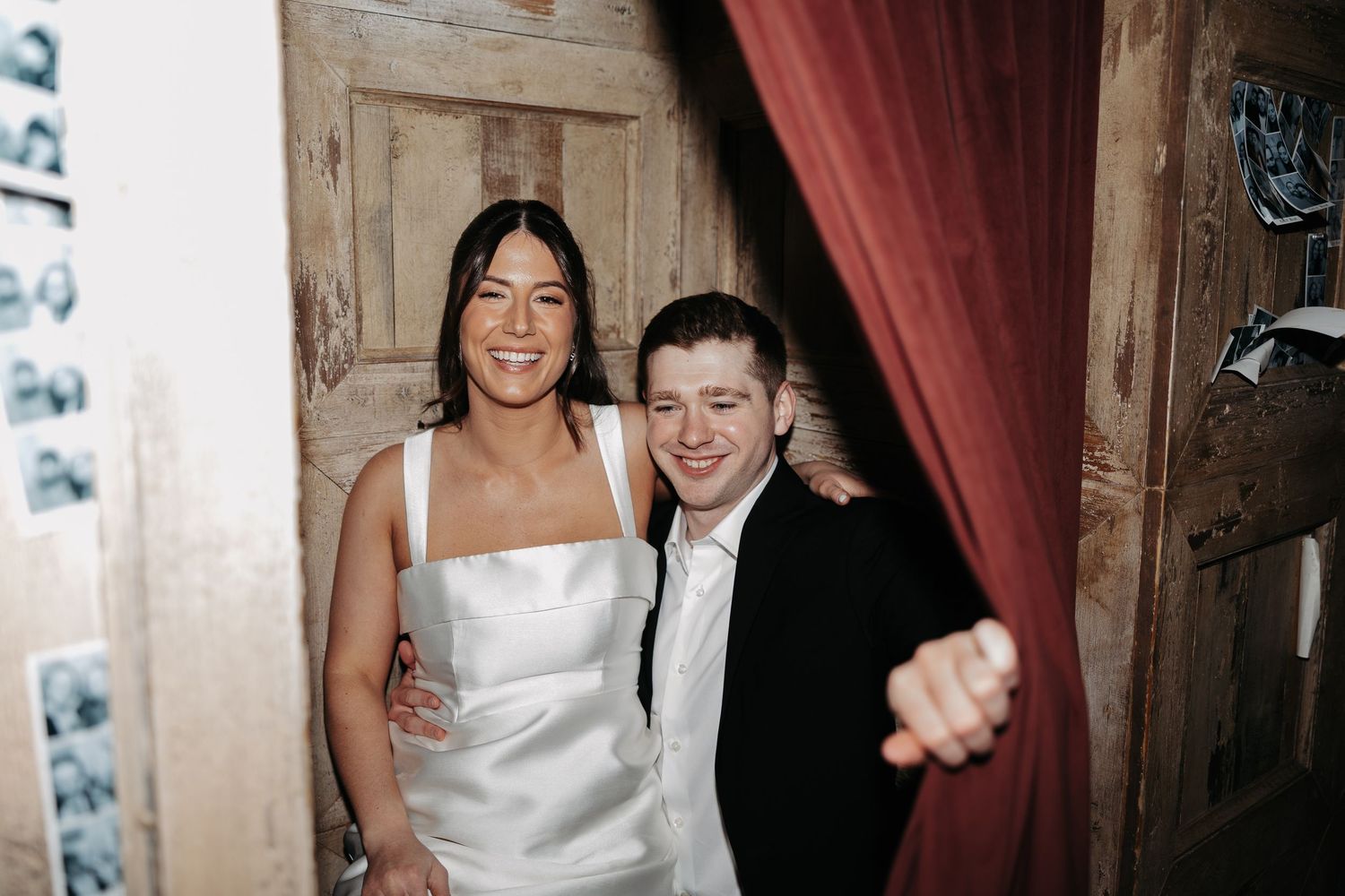A group of people in formal attire celebrating and dancing at what appears to be a wedding reception.
