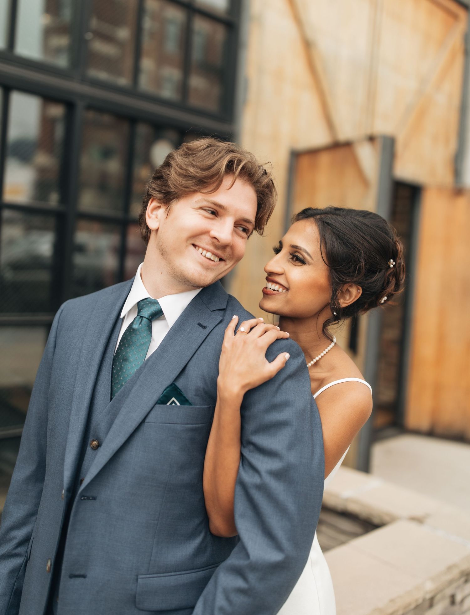 Intimate wedding portrait of couple sharing a joyful moment outdoors.