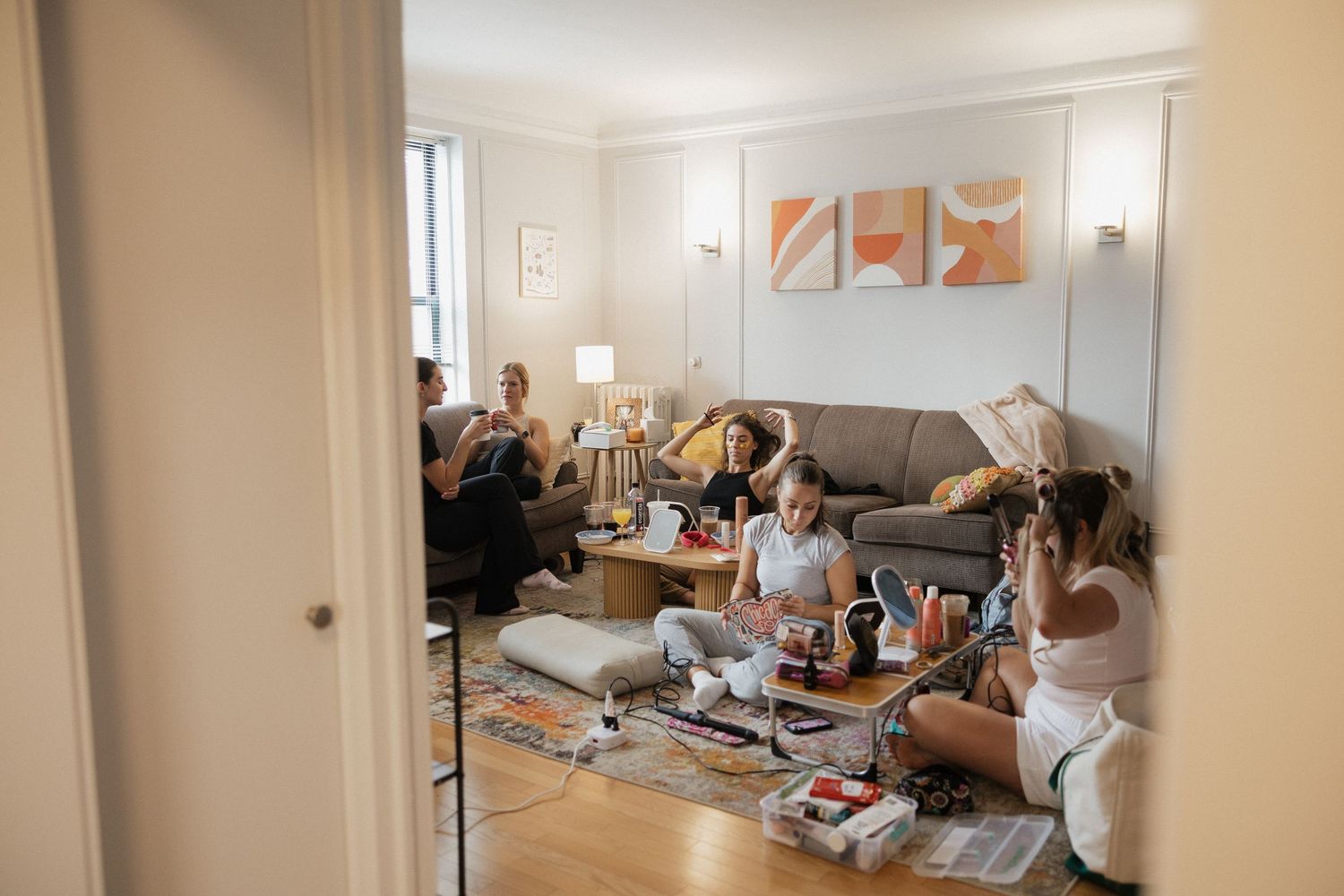 Panoramic view of a modern living room with gray sofa, white walls, and moving boxes during a relocation process.