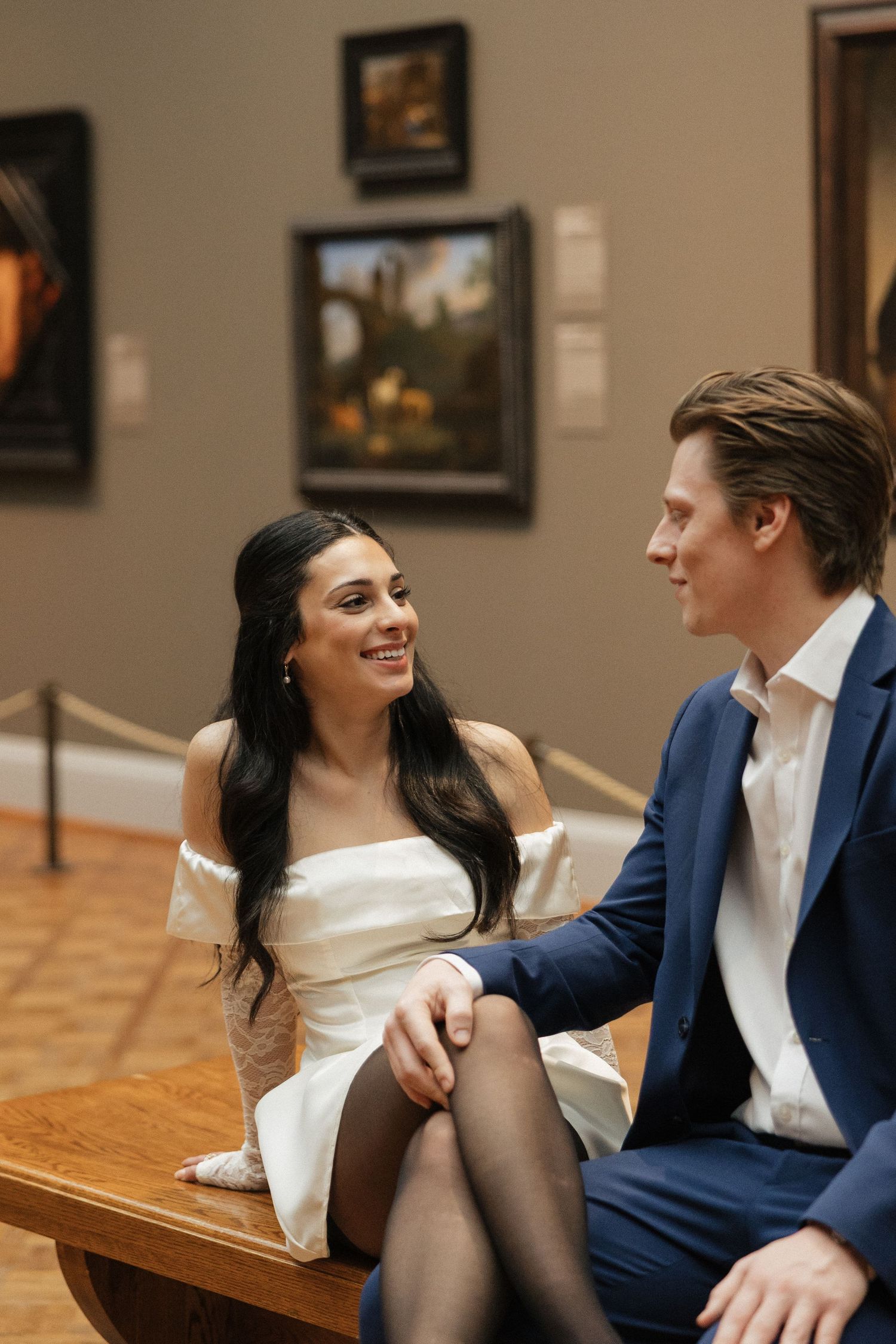 An intimate photo series of a couple sharing tender moments in a museum gallery setting.
