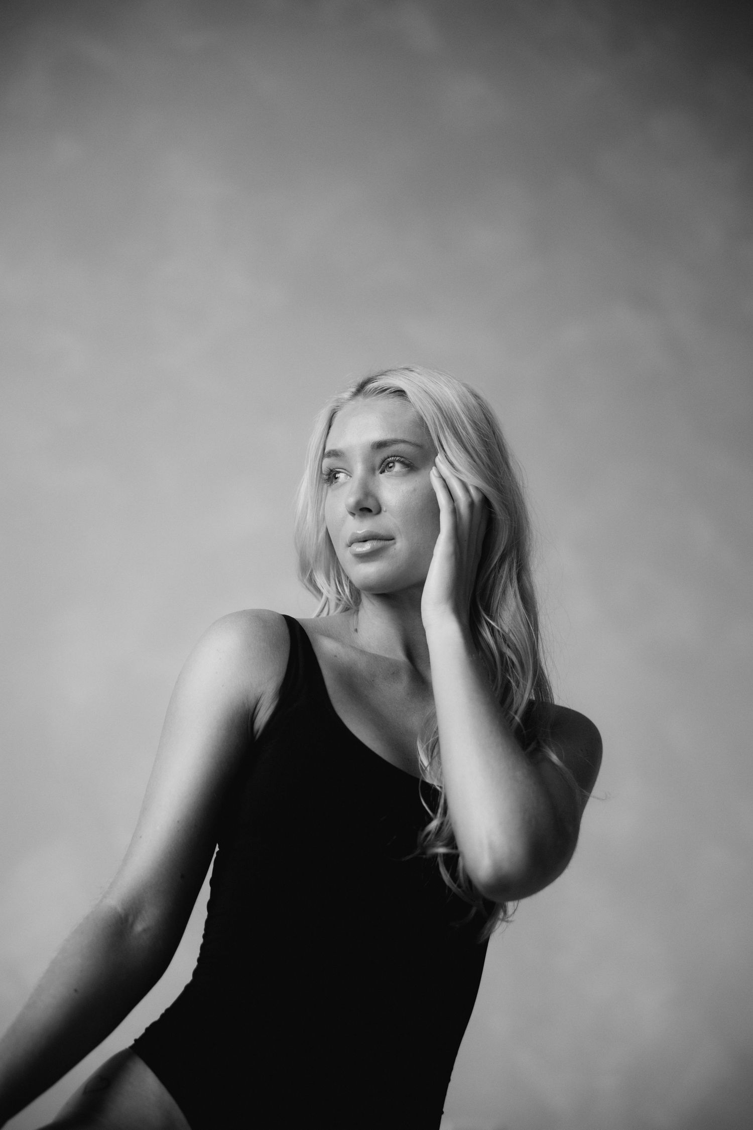 Moody monochrome photography sequence capturing emotive gestures against plain backdrop.